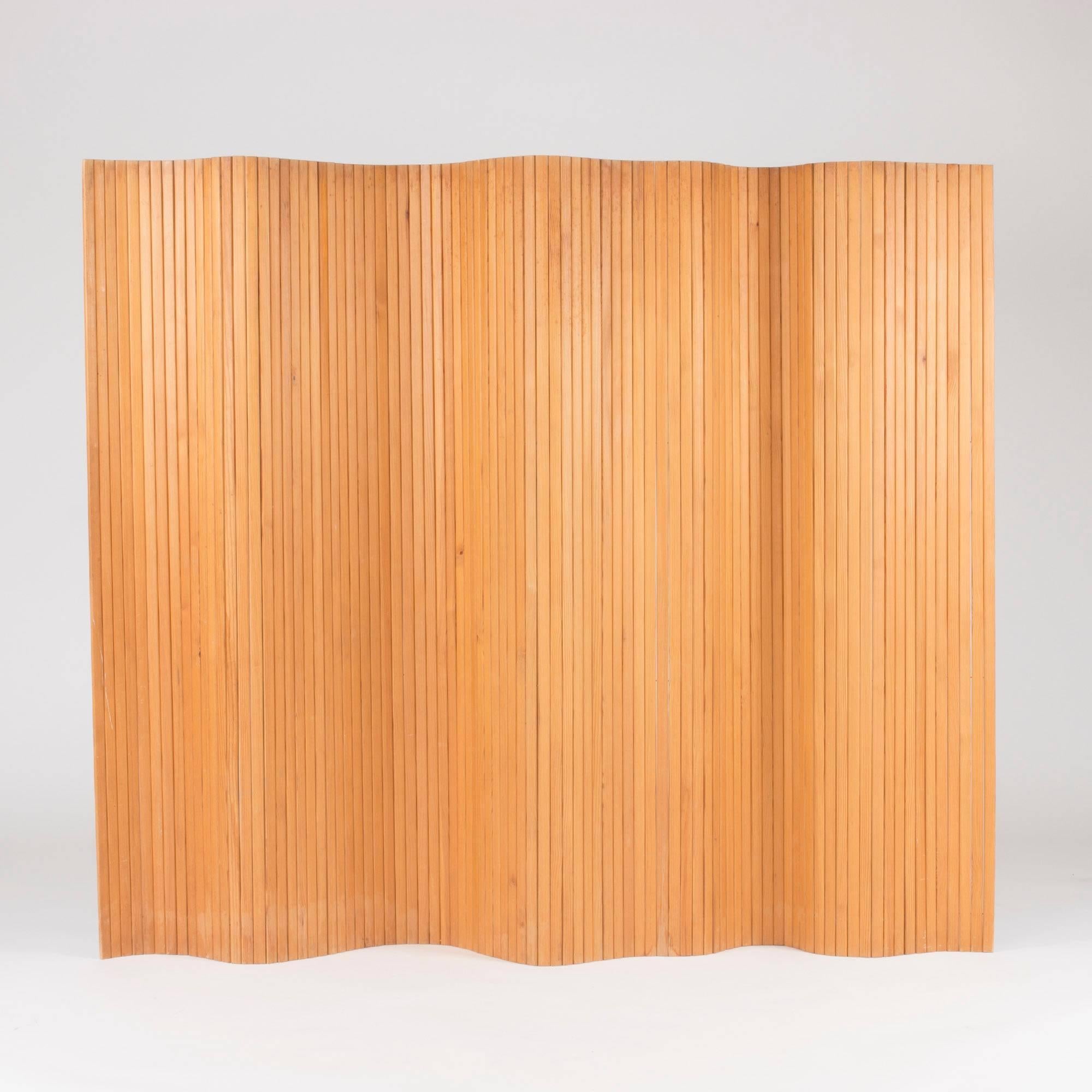 Beautiful room divider by Alvar Aalto, made from vertical slats of pine adjoined with metal wires. Can be shaped in various ways and stands steadily on the ground. Original condition with some scratches and spots.