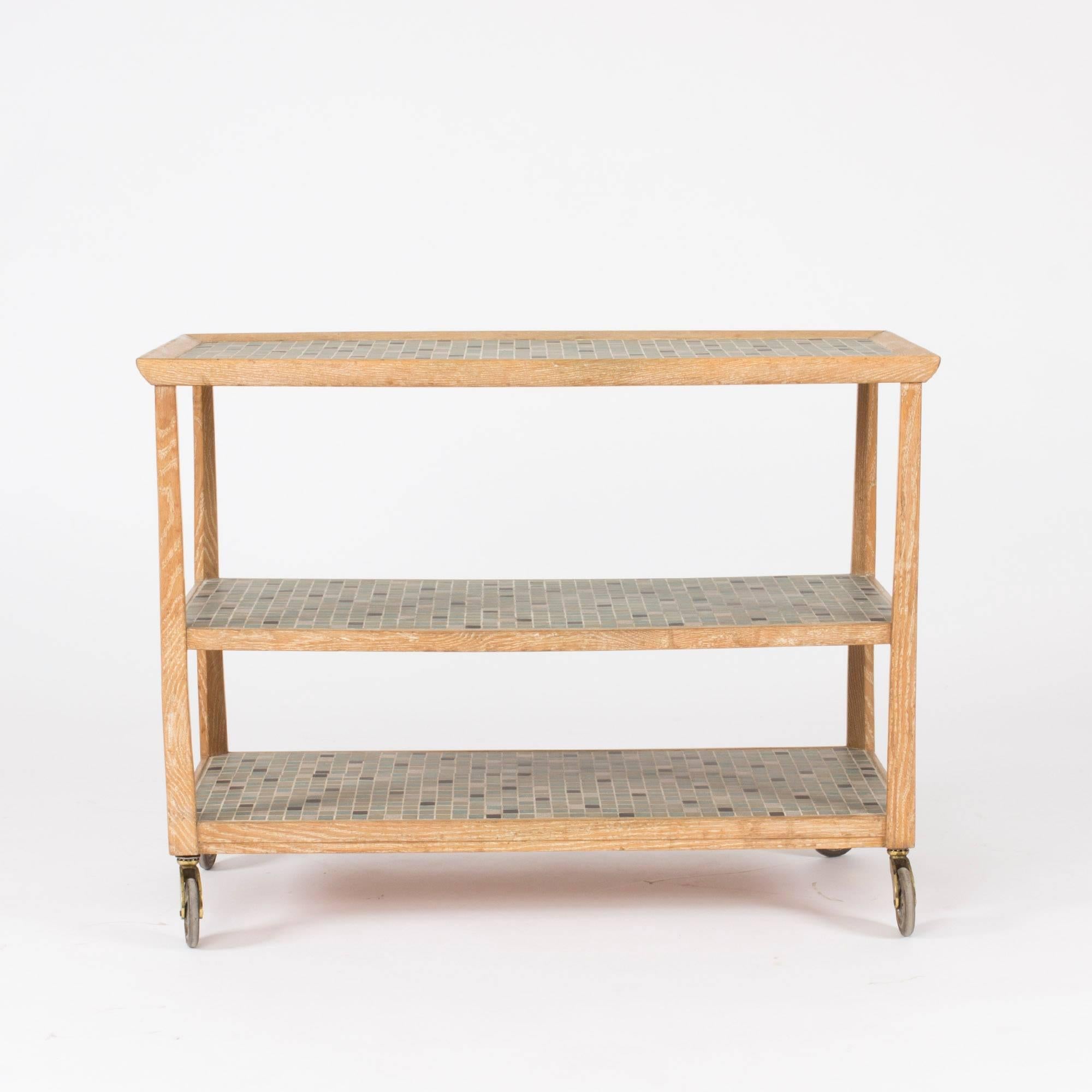 Beautiful bar trolley by Otto Schulz made from white-washed oak that brings out the wood grain in a great way. Shelves decorated with ceramic tiles in subdued greens and black. Wheels in great condition.