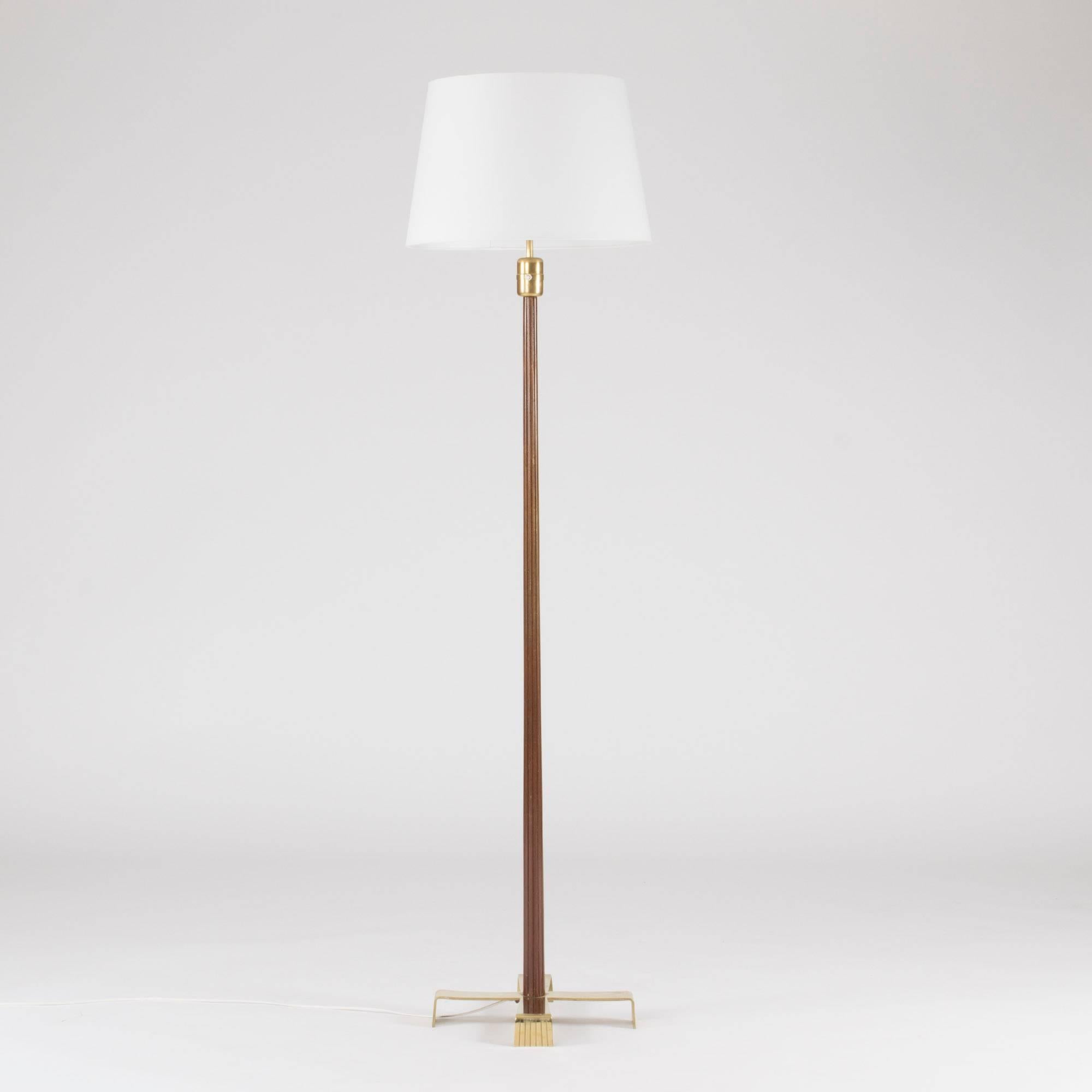Floor lamp by Hans Bergström with a striped mahogany handle and brass base. Elegant, cross-shaped base.
