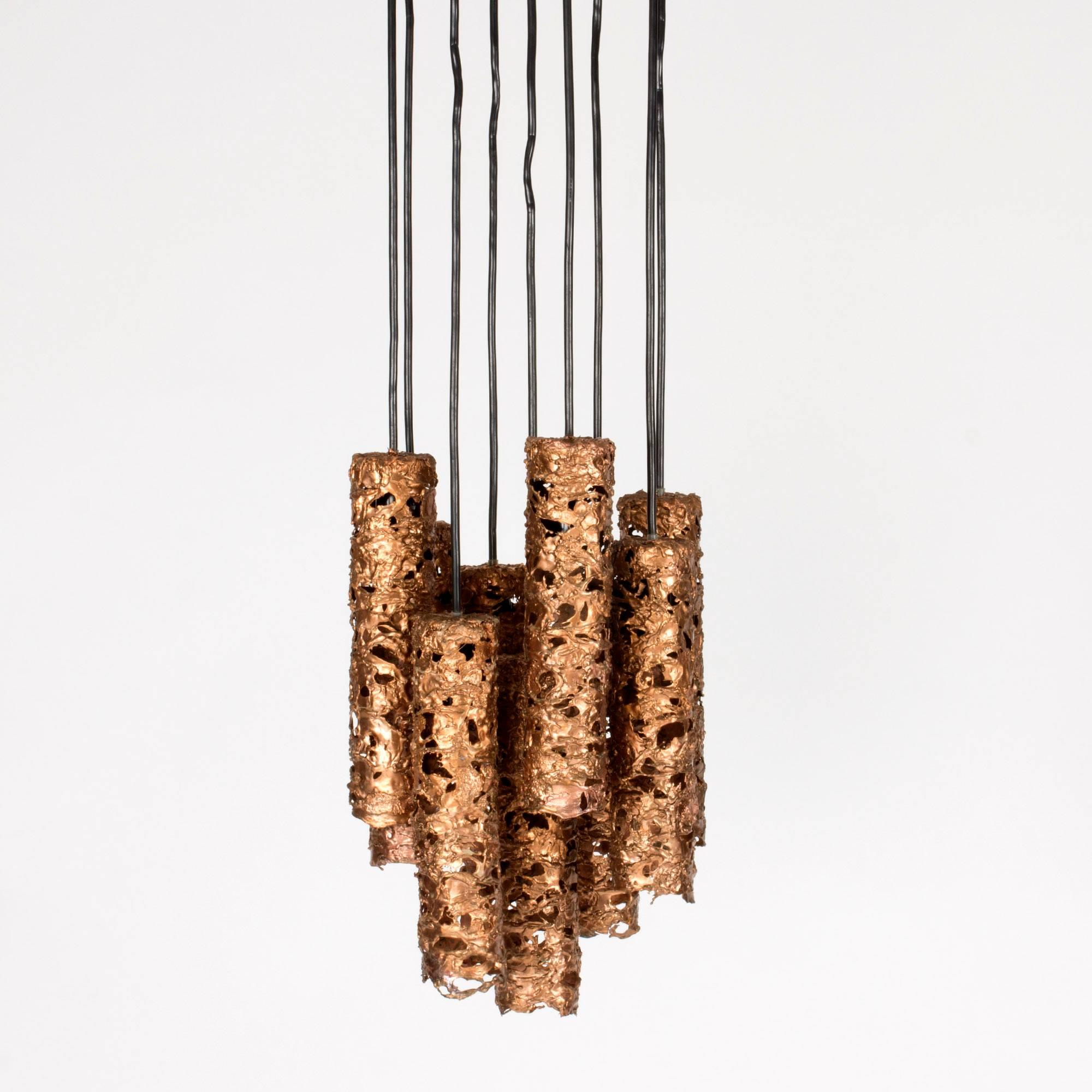 Awesome Swedish 1960s Brutalist pendant lamp, made from multiple cylindrical lamp shades suspended from a large cable cup in the same technique. The shades are made from shards of copper that let some light slip through the gaps between them.