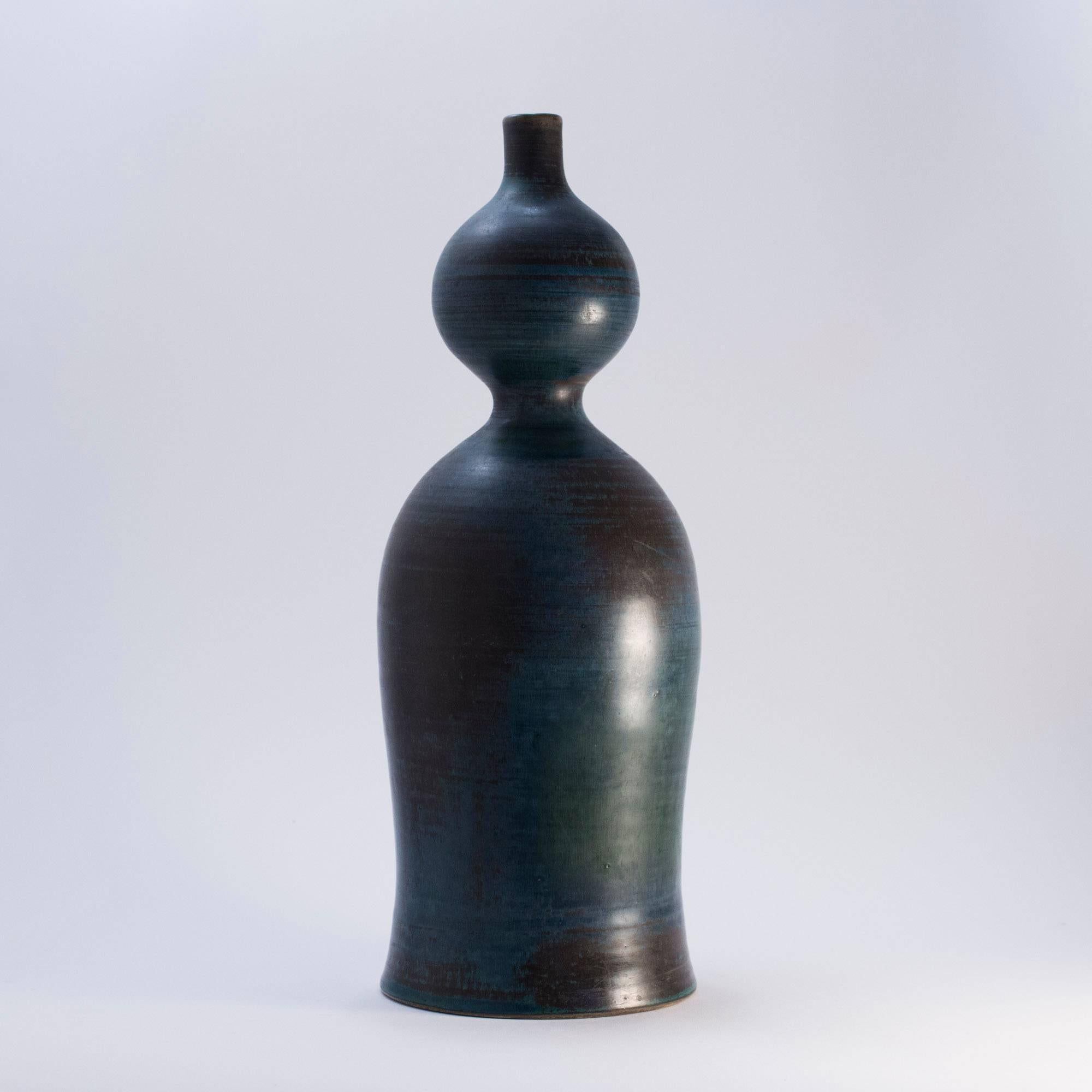 Amazing stoneware vase in a rare design by Stig Lindberg. Undulating silhouette with oriental connotations, yet distinctly Stig Lindberg in style. Sweeping petrol blue glaze alternating with thunderstorm grey in this one-off piece. A real