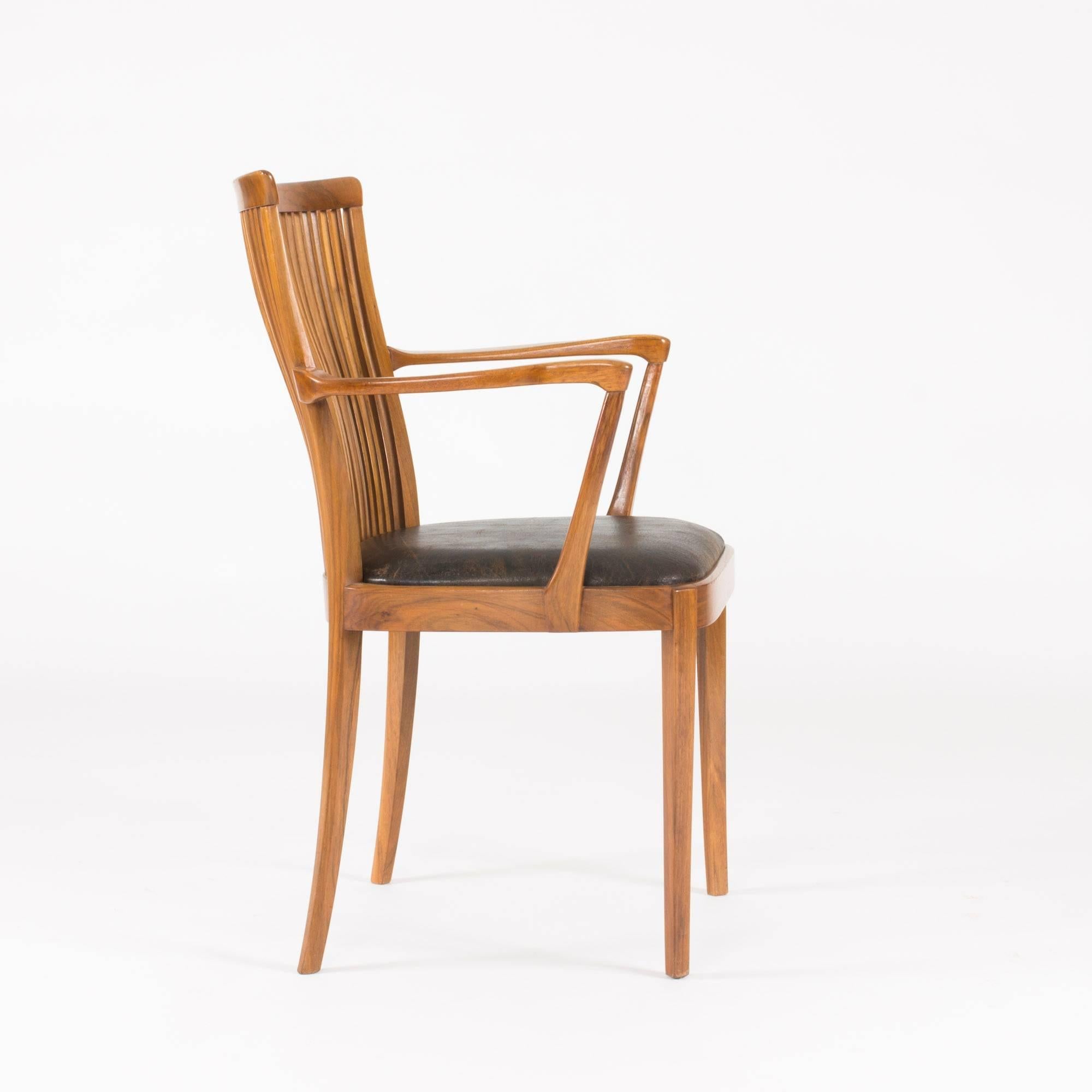 Luxurious armchair by Carl-Axel Acking, beautifully executed by master carpenter Hjalmar Jackson. Made from walnut with a brown leather seat. Graceful, modernist design.

Carl-Axel Acking was a Swedish architect, furniture designer and professor