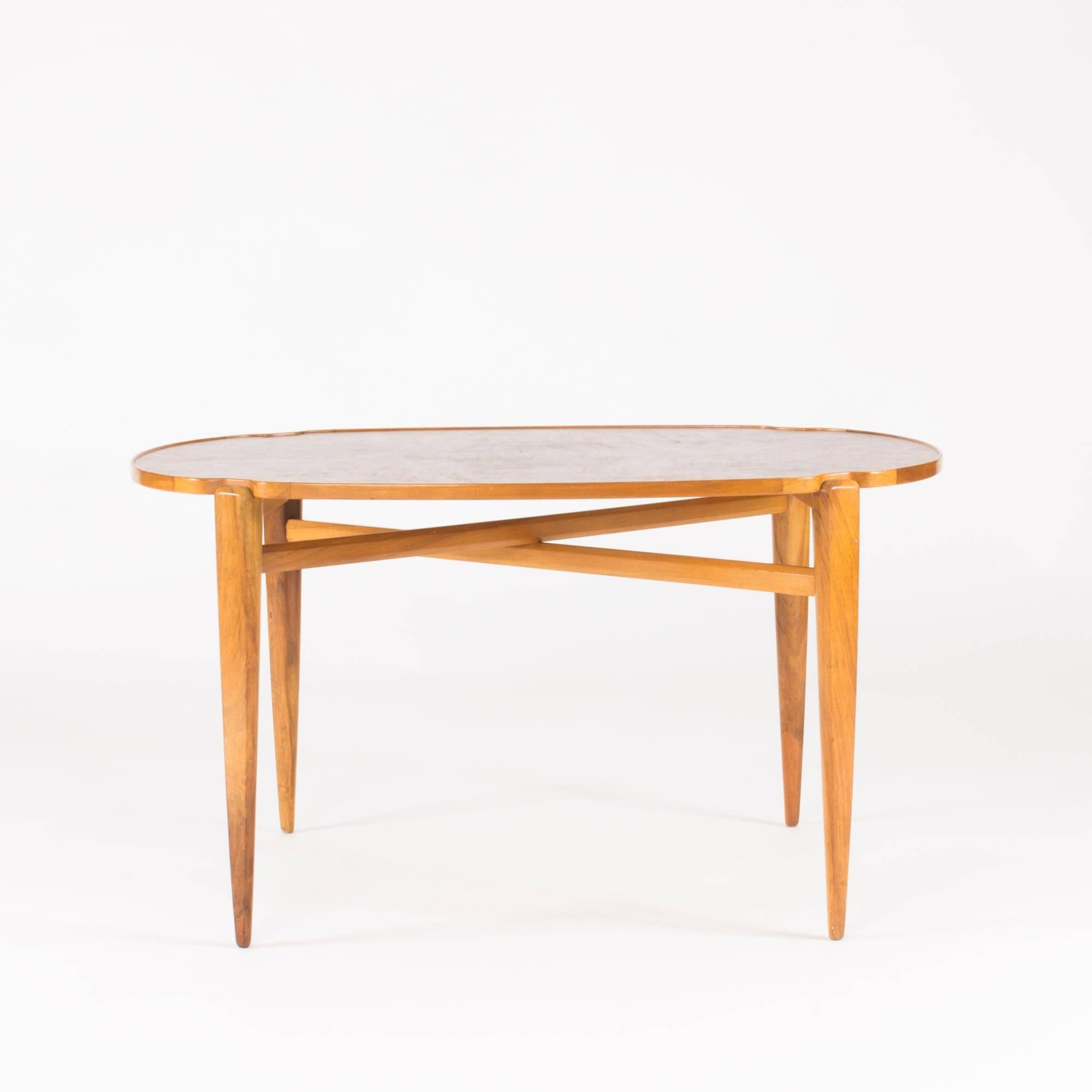 Exquisite coffee table by Axel Larsson with a walnut root tabletop and walnut base, executed by master carpenter Hjalmar Jacksson at Stockholms Hantverksförening. The tabletop has a dramatic, dark color and pattern and a rim around the edge in a