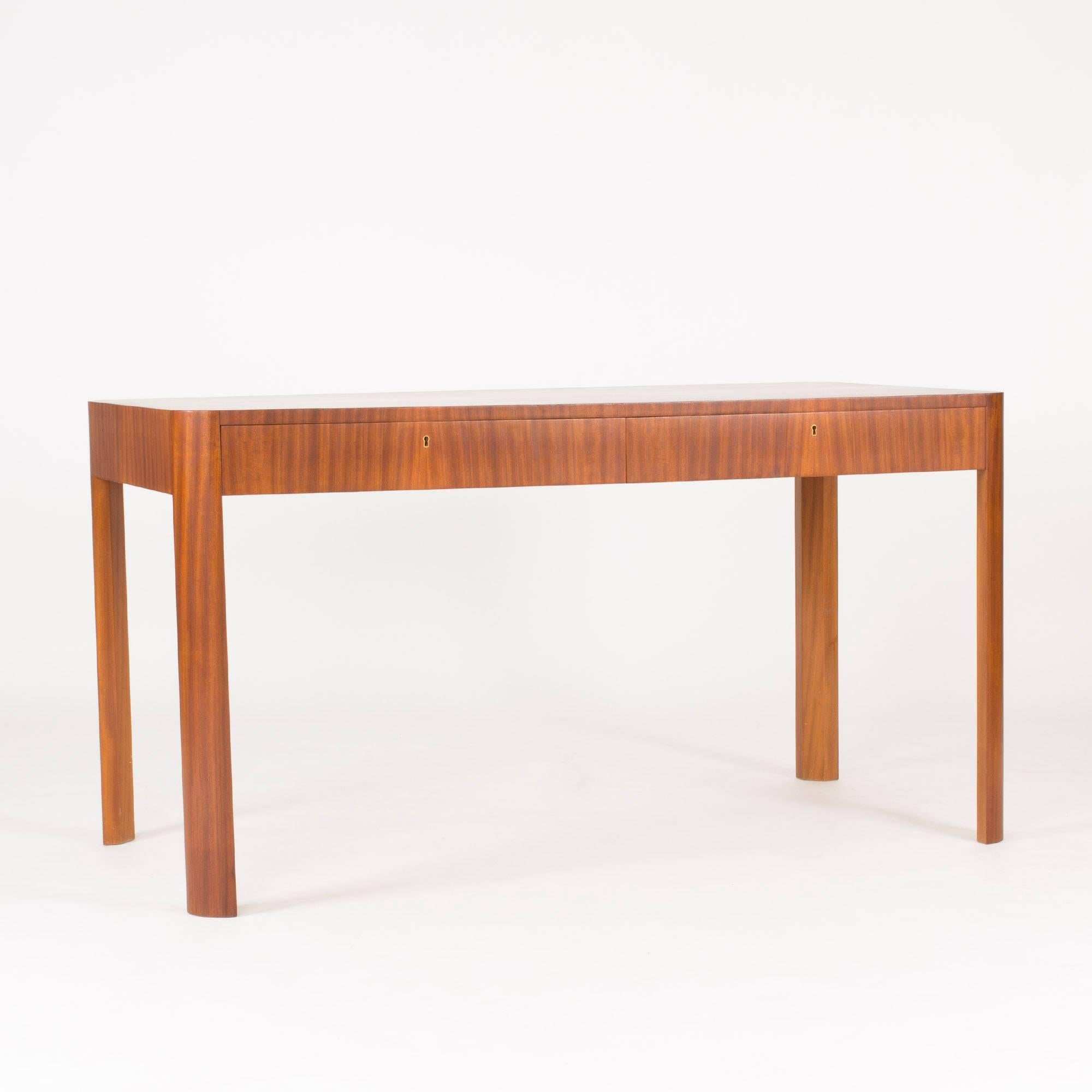 Beautiful functionalist desk, in all likelihood designed by Margareta Köhler for her company Futurum. Great mahogany veneer laid in vertical stripes on the sides. Rounded corners and legs give softness to the strict design. Some small repairs have