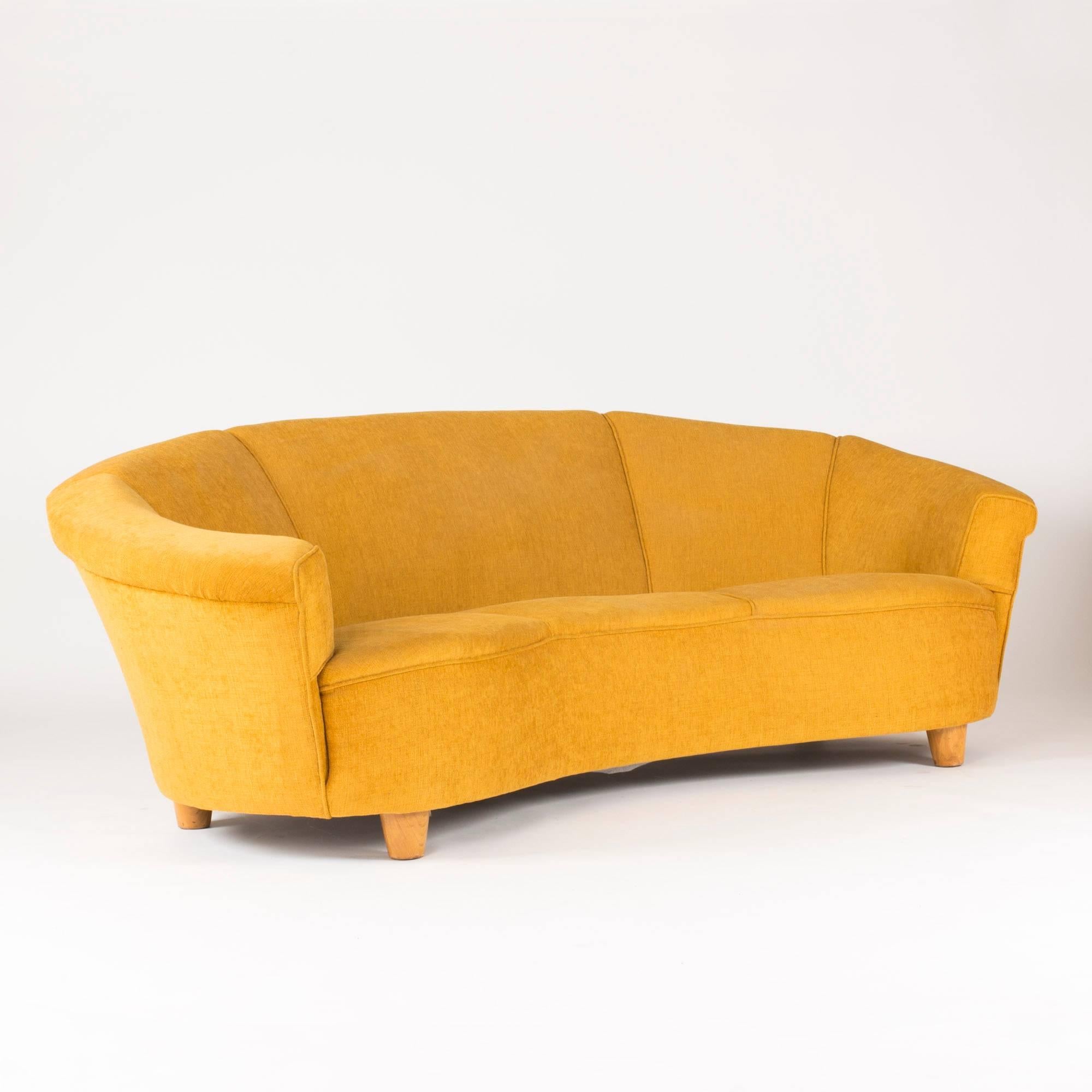 Luxurious, voluminous sofa in an inviting, curved shape with mustard yellow upholstery. In the style of Otto Schulz. Seat height 43 cm.