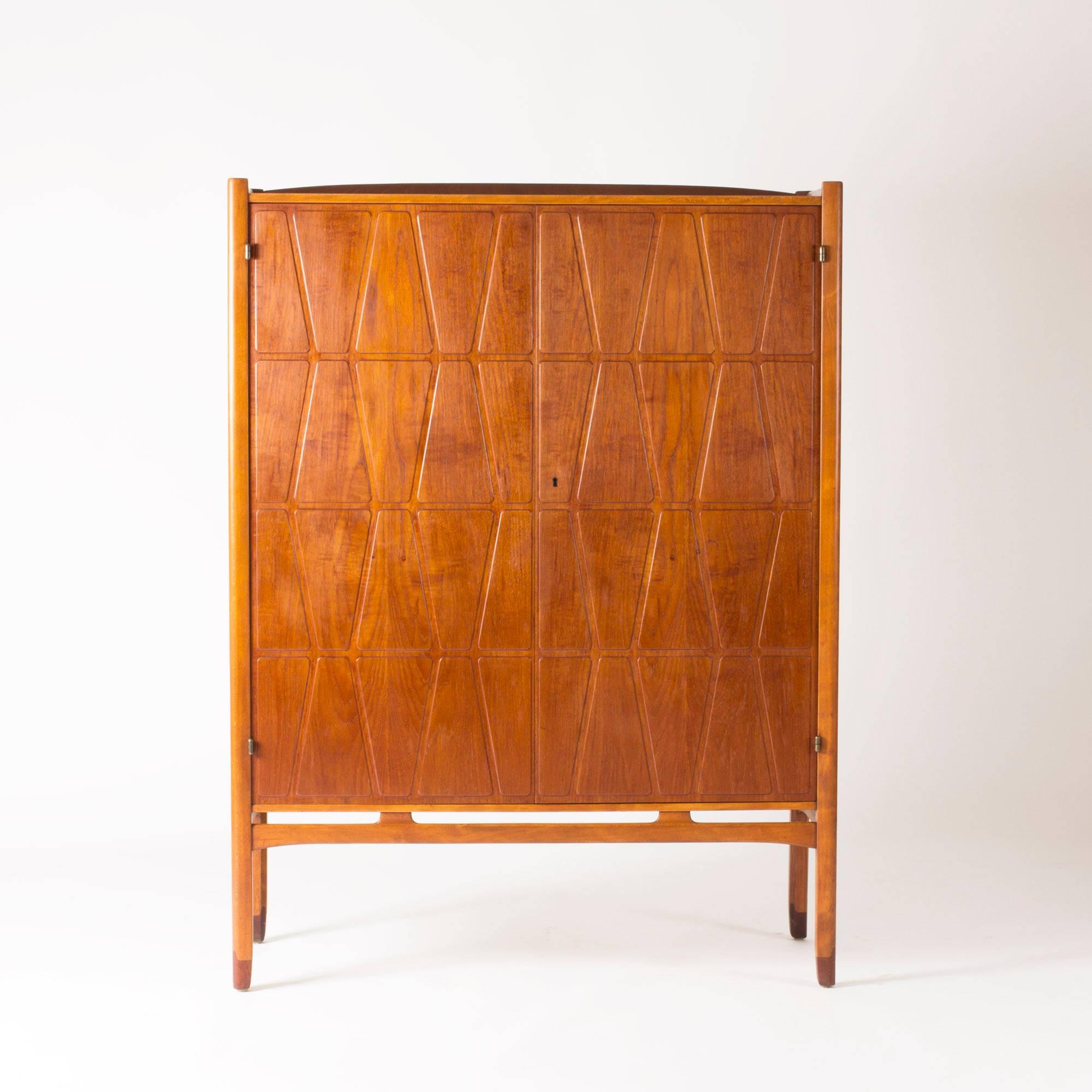 Striking “Bangkok” cabinet by Yngve Ekström, made from teak with a graphic, embossed pattern on the door fronts. Details made in beech create a subtle contrast.
