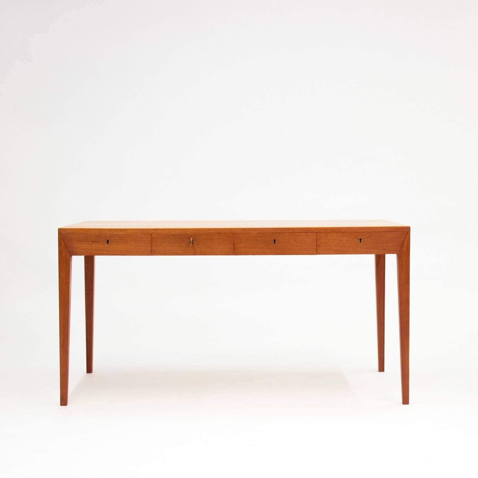 Striking teak desk by Severin Hansen for Haslev Møbelfabrik, with perfect proportions and Severin Hansen’s characteristic diagonal, seamless joinery at the corners. Four drawers with a brass key.