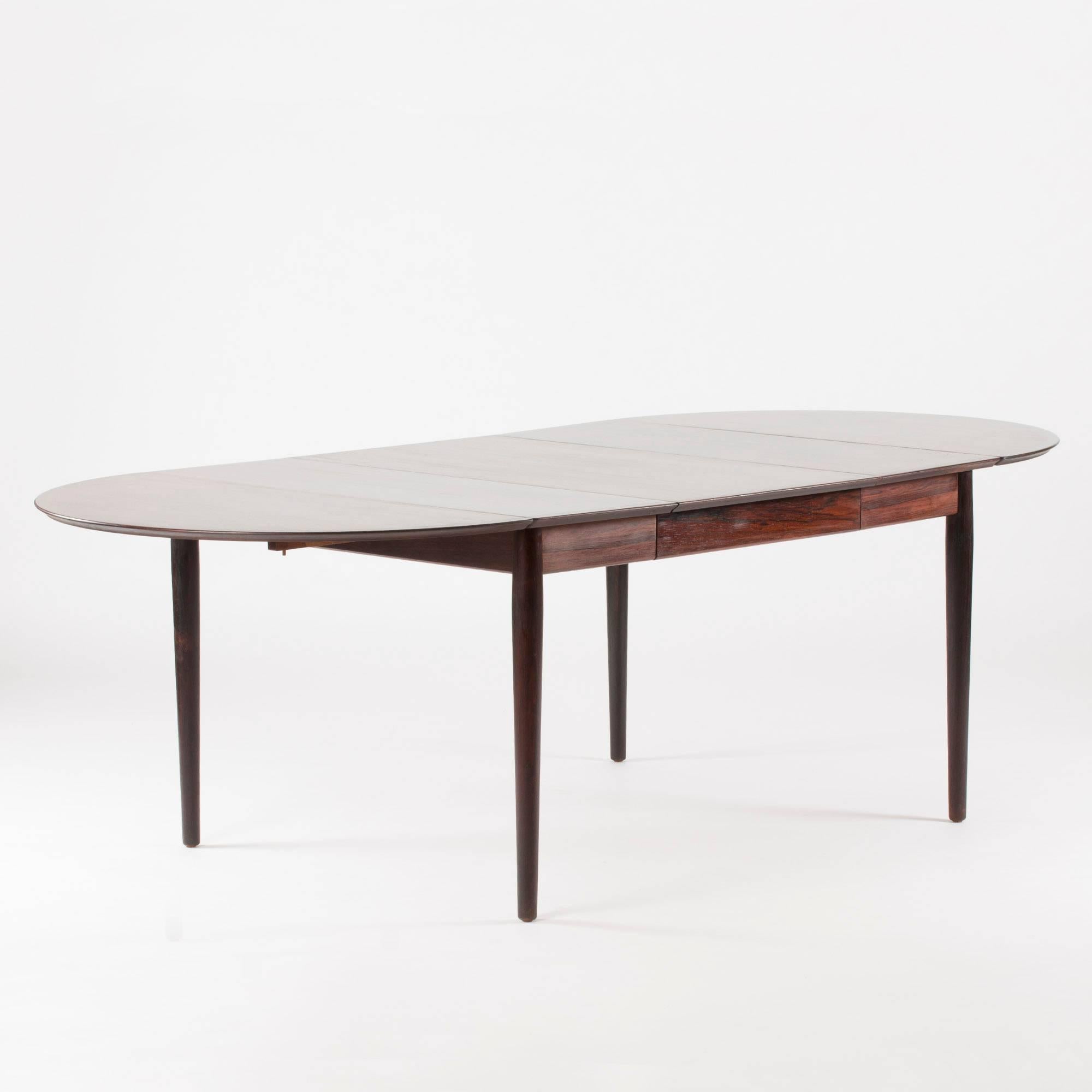 Sleek rosewood dining table by Arne Vodder, with removable drop leaves and two extra leaves. The total length with both extra leaves is 290 cm.