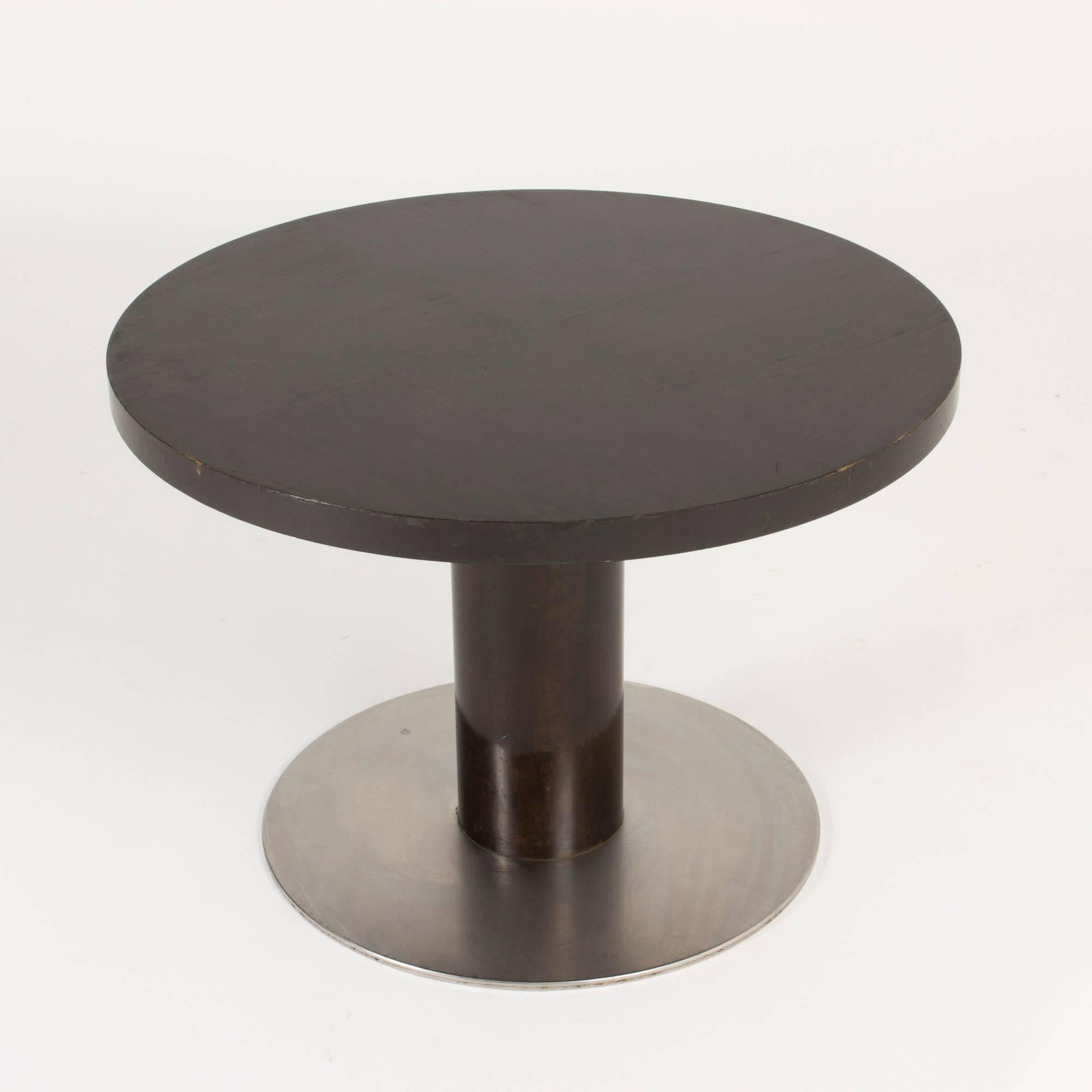 Round coffee table model “Typenko” by Axel Einar Hjorth for NK. Striking in its simplicity, made from black lacquered birch with a stainless steel base.