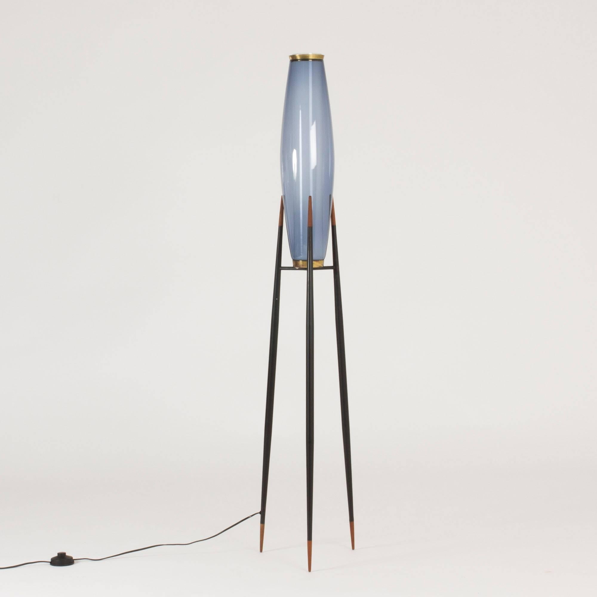 Stunning floor lamp by Svend Aage Holm Sørensen, made of black lacquered metal with teak and brass details. Inner opaline glass shade and an outer Smokey blue. A remarkable floor lamp with its large light on spindly legs. New wiring.