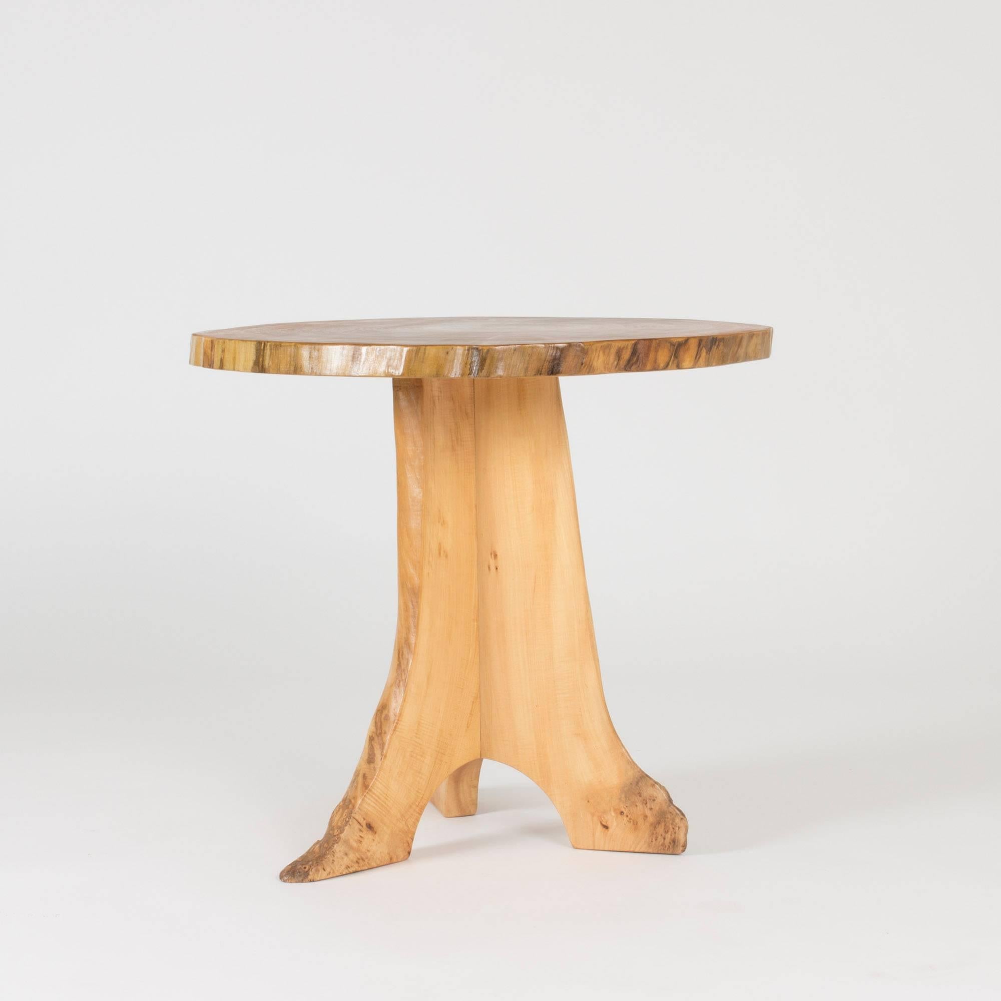 Organic occasional table by Sigvard Nilsson, made from poplar with a pedestal base. The table top is made of a sheet of a tree trunk that shows the annual rings. The base is made from pieces of wood where curves of the tree has been used to create