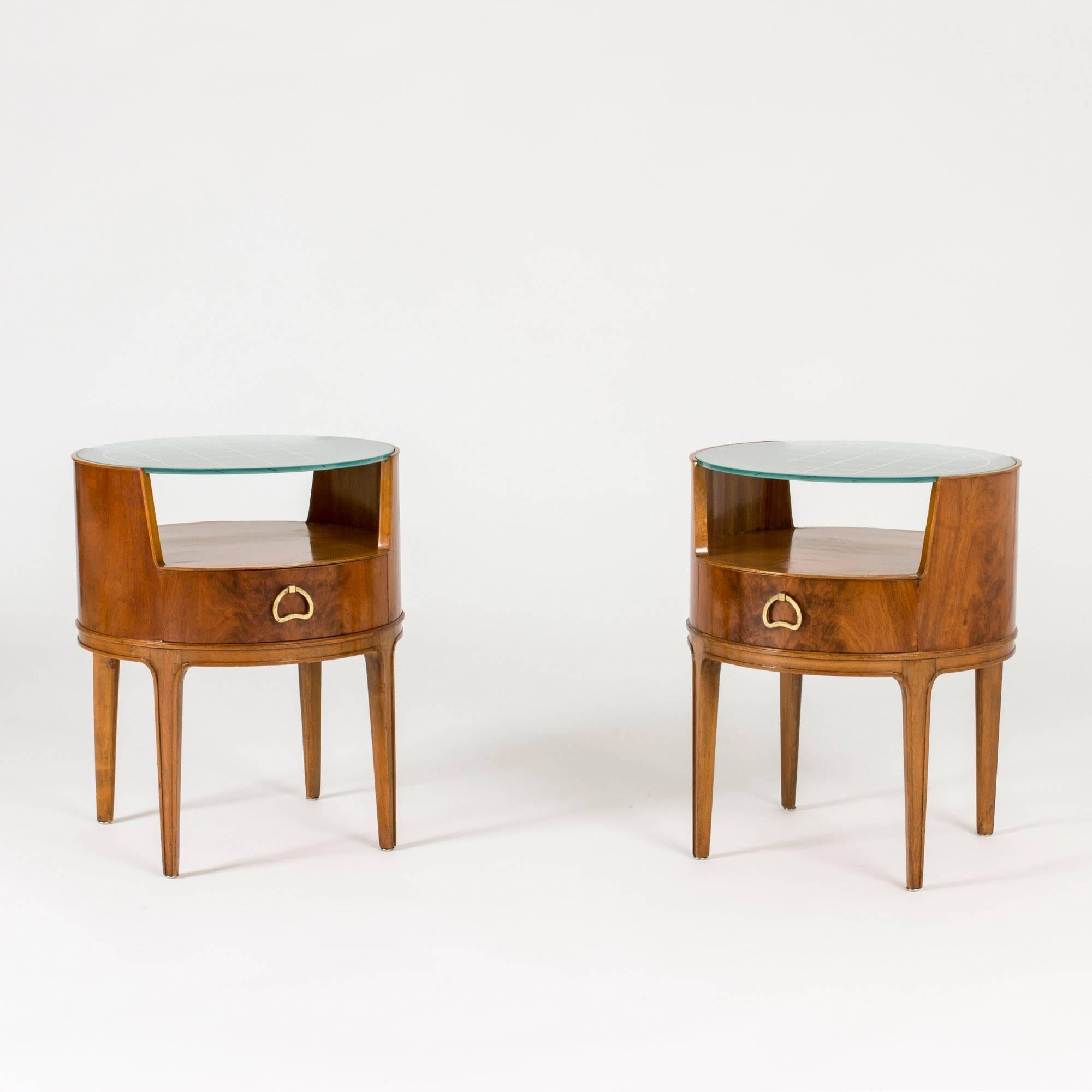 Pair of beautiful bedside tables by Axel Larsson, with pyramid mahogany veneer, green tinted glass tops and sculpted brass handles. The glass tops have an etched checkered pattern.
