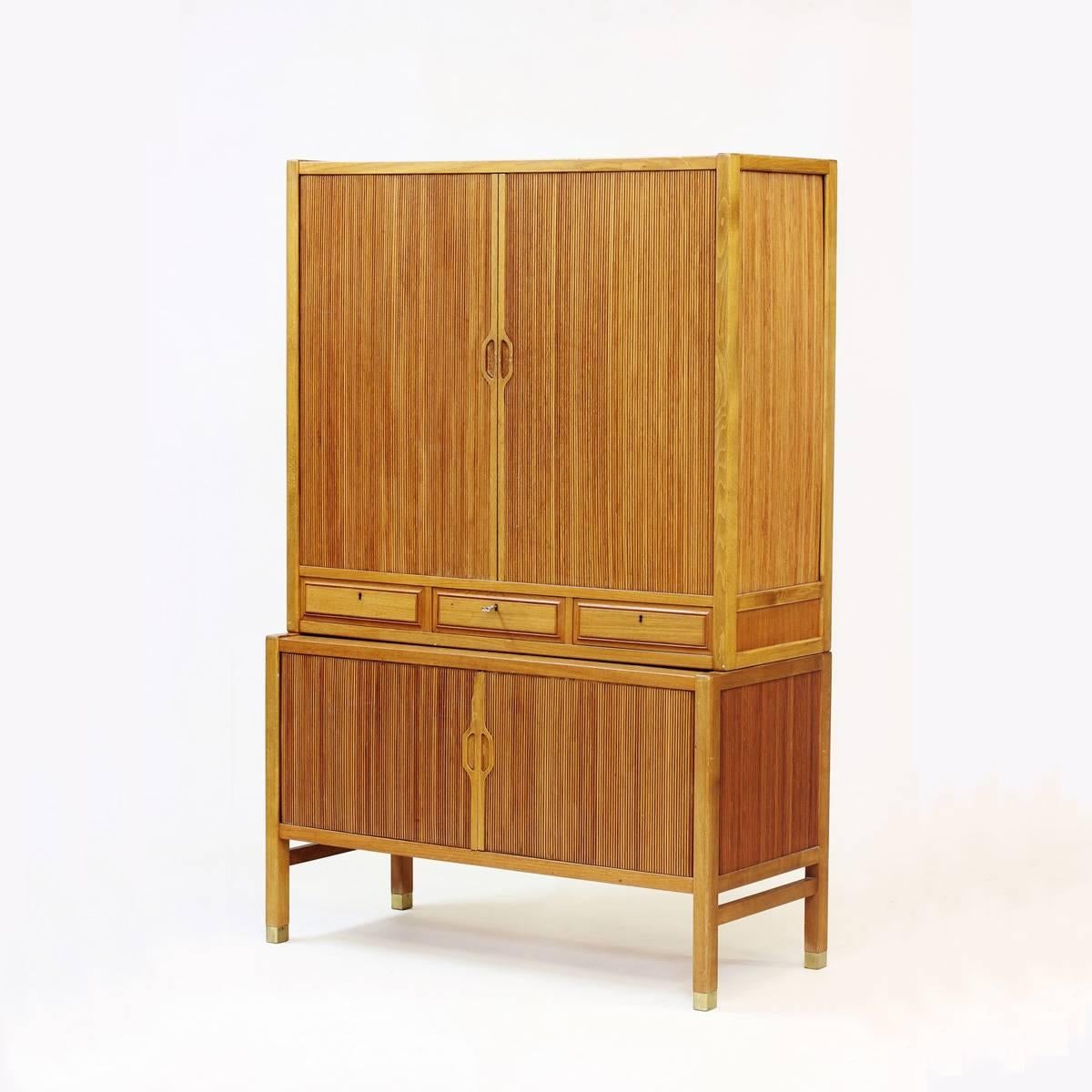 Very elegant oak frame and teak veneer cabinet with jalousie doors by Carl-Axel Acking for Bodafors. Three shelves in the upper cabinet and two in the bottom. Three front drawers with the original key. Straight legs with brass endings. Very nice