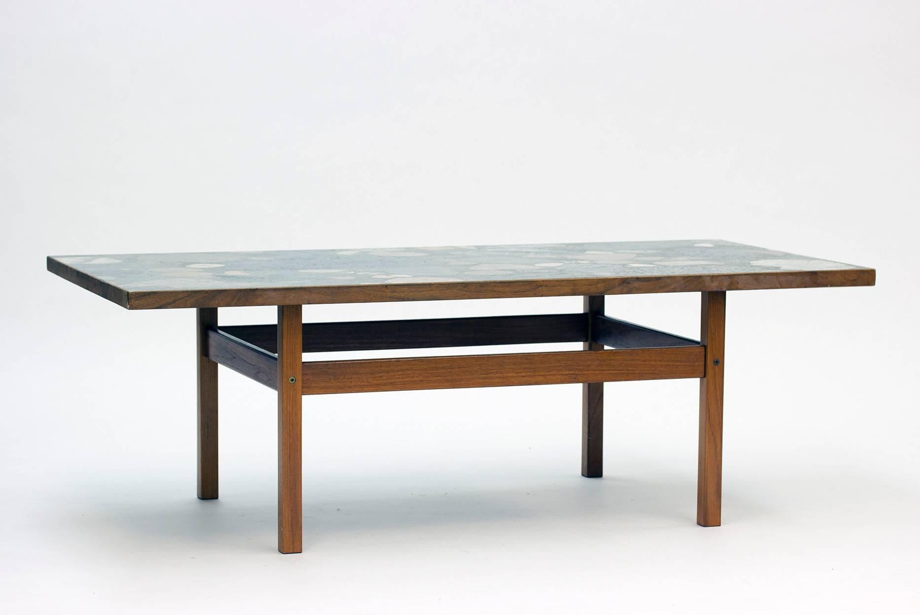 Beautiful teak table with stone top by Norwegian architect Erling Viksjø. The stones and shards of different sizes and colors are molded in concrete, creating associations to stony beaches and sea beds.