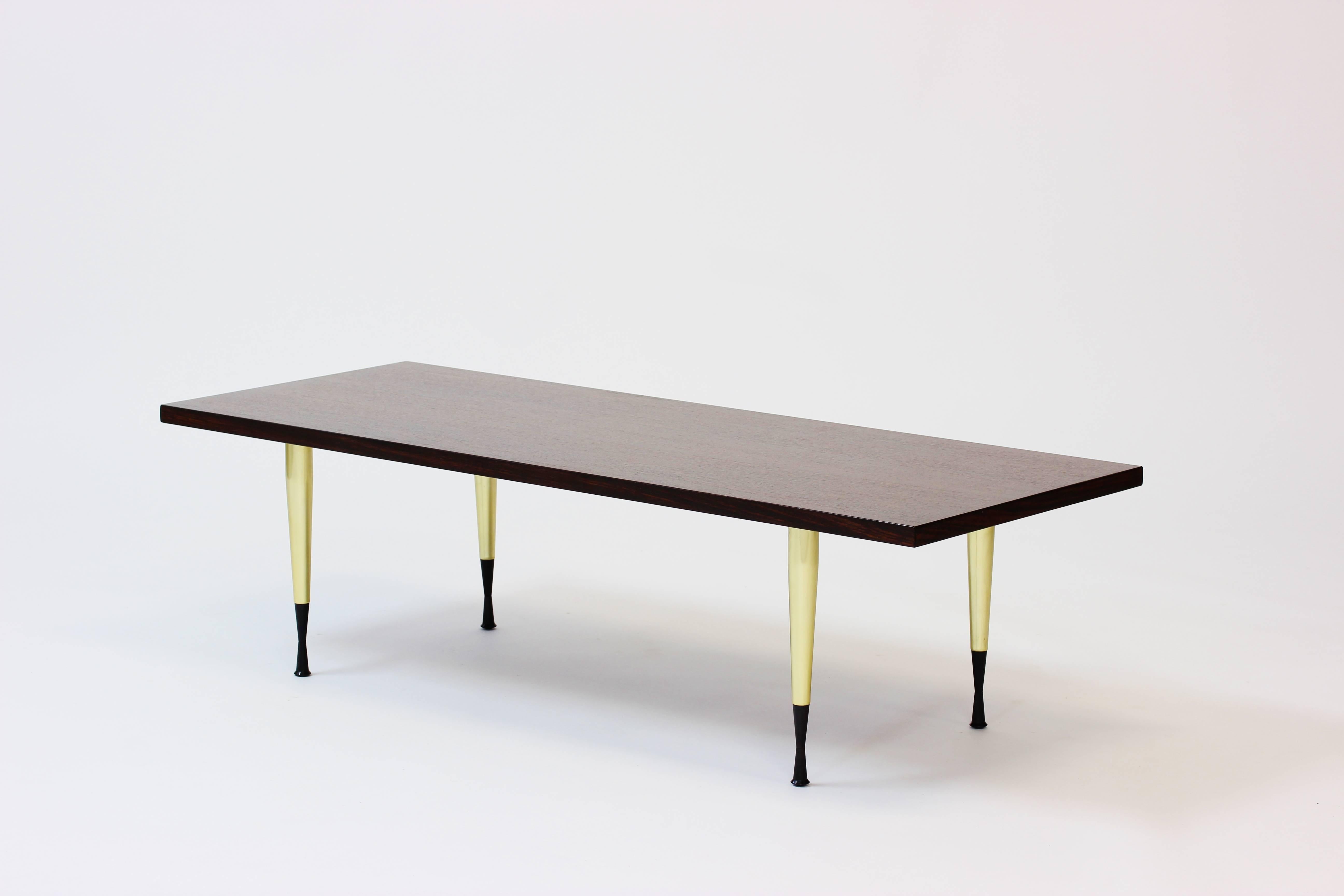 Cool coffee table made in from NK (Nordiska Kompaniet). The brass legs are Italian and imported by NK to give the walnut table top a stylish Italian accent. Marked “NK Furniture” underneath.