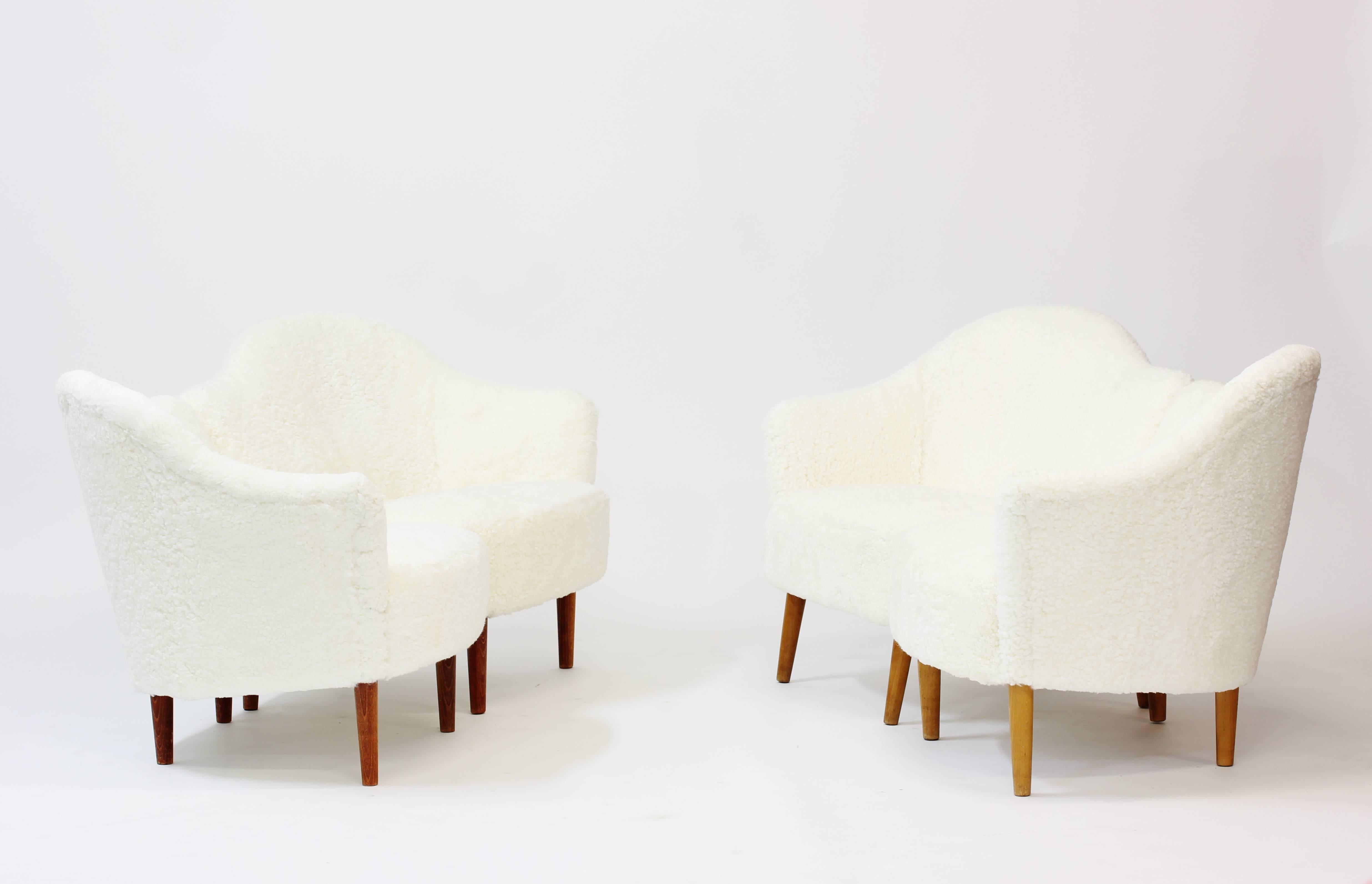 Lovely pair of Swedish 1950s easy chairs attributed to Carl Malmsten, similar to his Classic “Samspel” sofa. Makes a loveseat sofa when put together. Reupholstered in sheepskin.