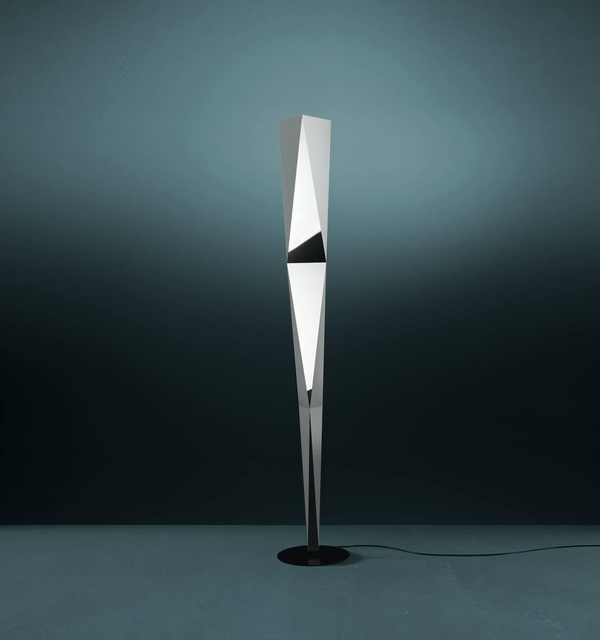 Esta lámpara de pie de luz indirecta, con sus características esquinas y bordes afilados, es el resultado de doblar una fina lámina de aluminio. La estructura está montada sobre una base de acero y puede girar 320°.

Lámpara de pie de haz