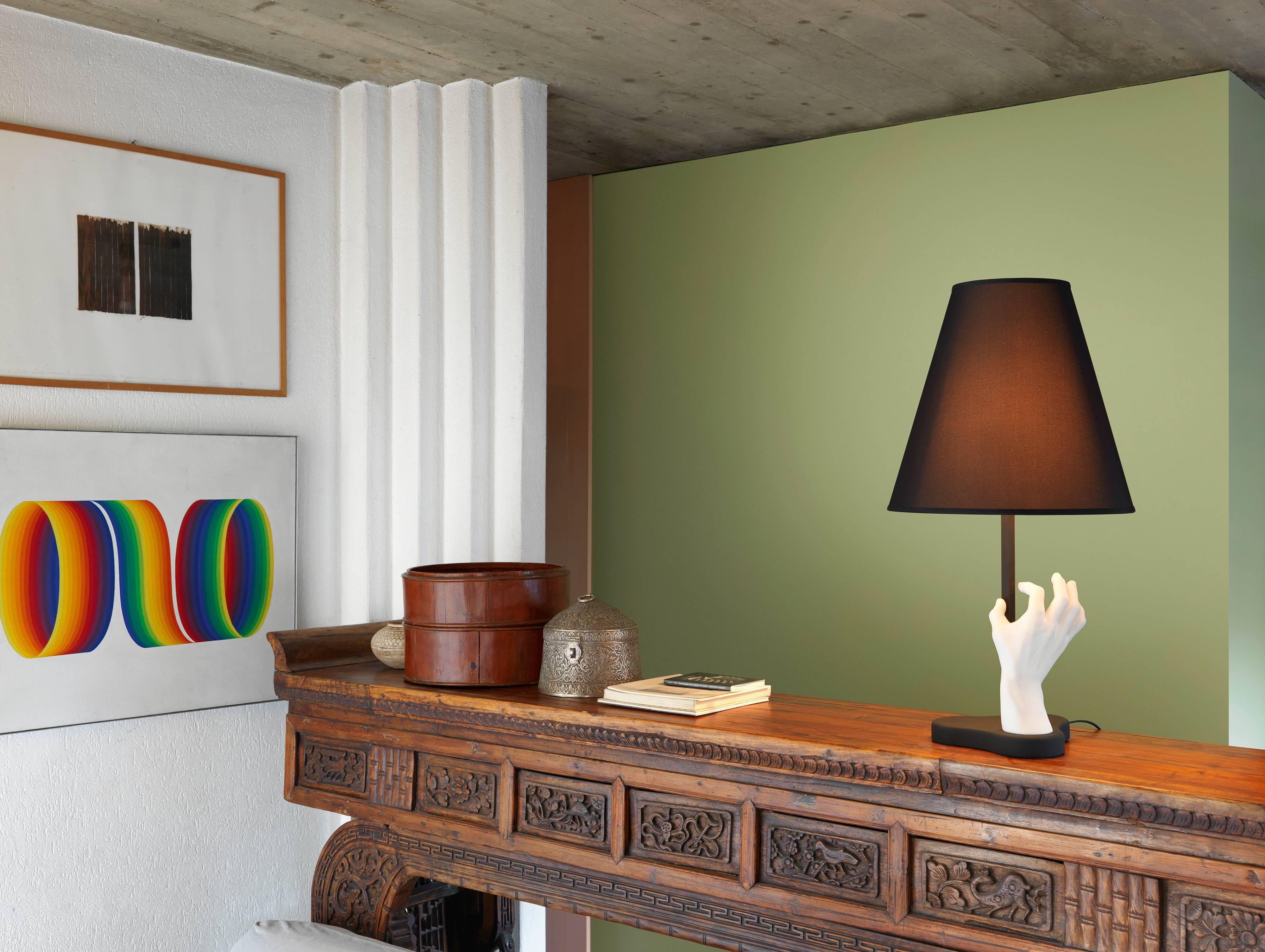 Esta lámpara, que marca tendencia por su ironía y elegancia, se compone de una base y una mano de polvo de mármol y resina, y un vástago de sección cuadrada de metal.
El difusor es de tela negra.

Lámpara de mesa con regulador de intensidad. Base