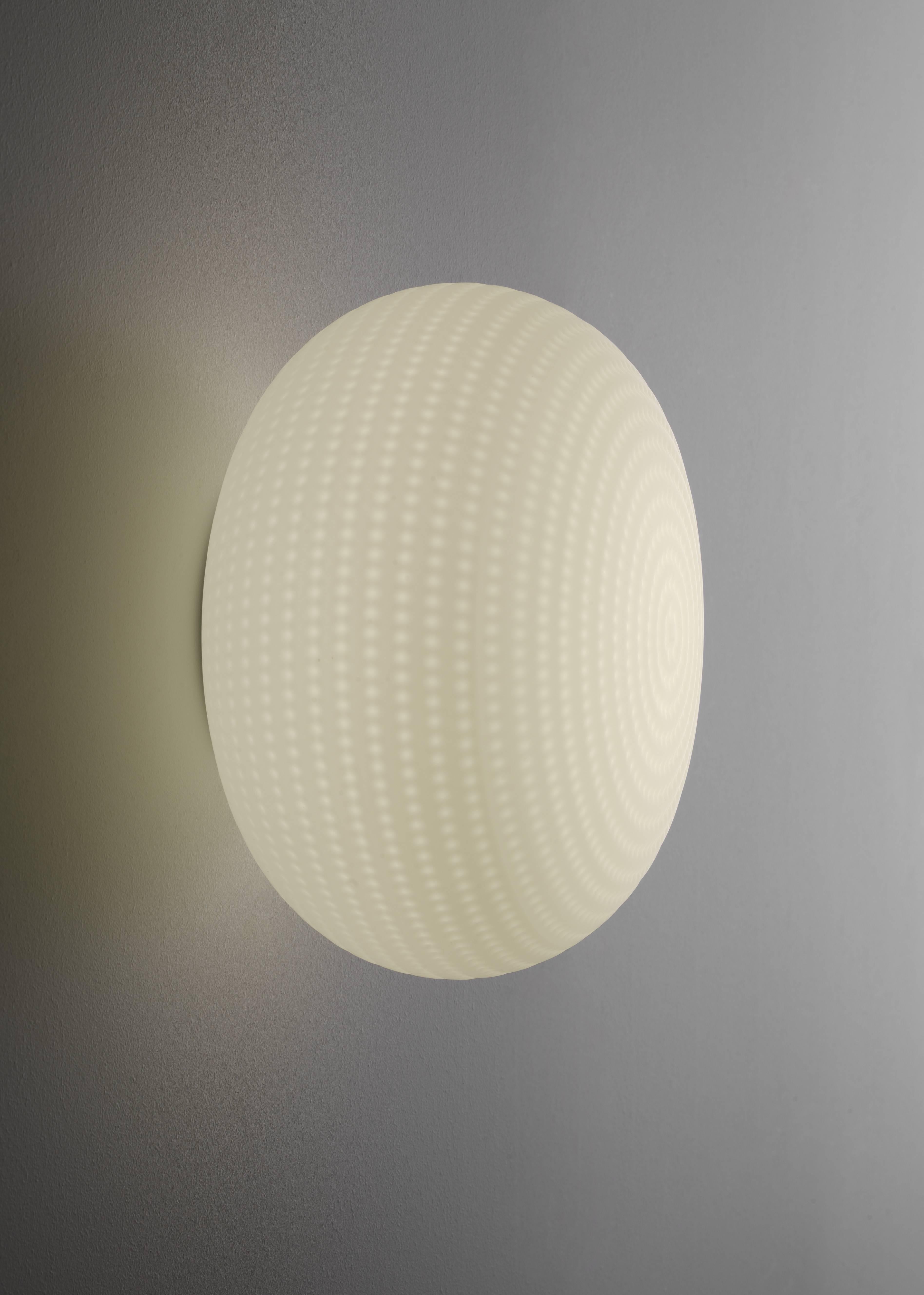 Its beautifully balanced shape is enriched and made unique by an orderly series of delicate, light grooves that, on the white volume of the glass, look like tiny prints on fresh snow.

Dimensions: (ø 30 × 20 cm)
Bulbs: 17,5W ( 2700 K, CRI >80, 1650