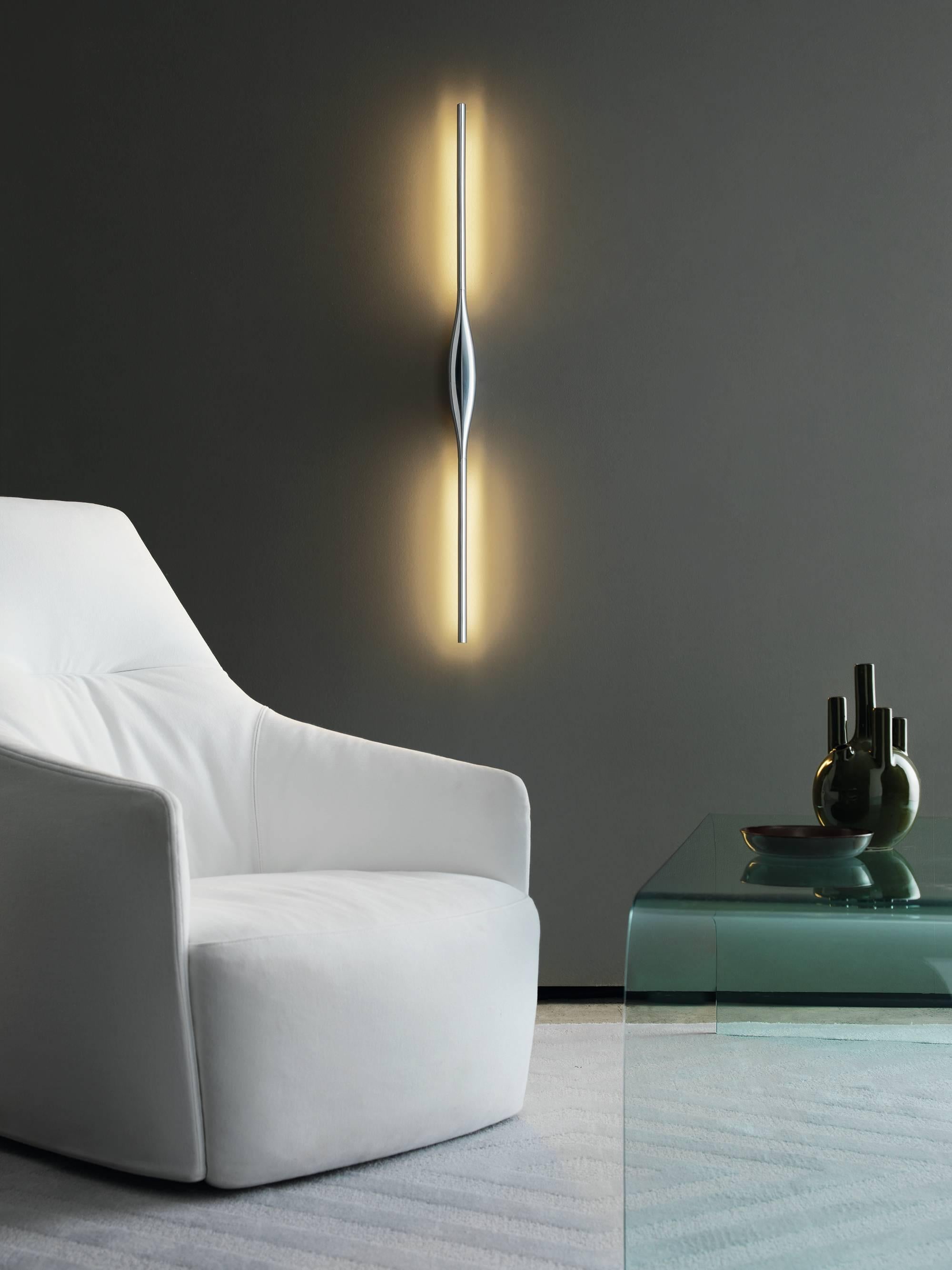 The Apex is a wall lamp in metal and polymer by designer Karim Rashid manufactured by Fontana Arte, 2017, is distinguished by its elegant, streamlined design and eye-shaped centre. Each end of the lighting fixture tapers off and almost disappears