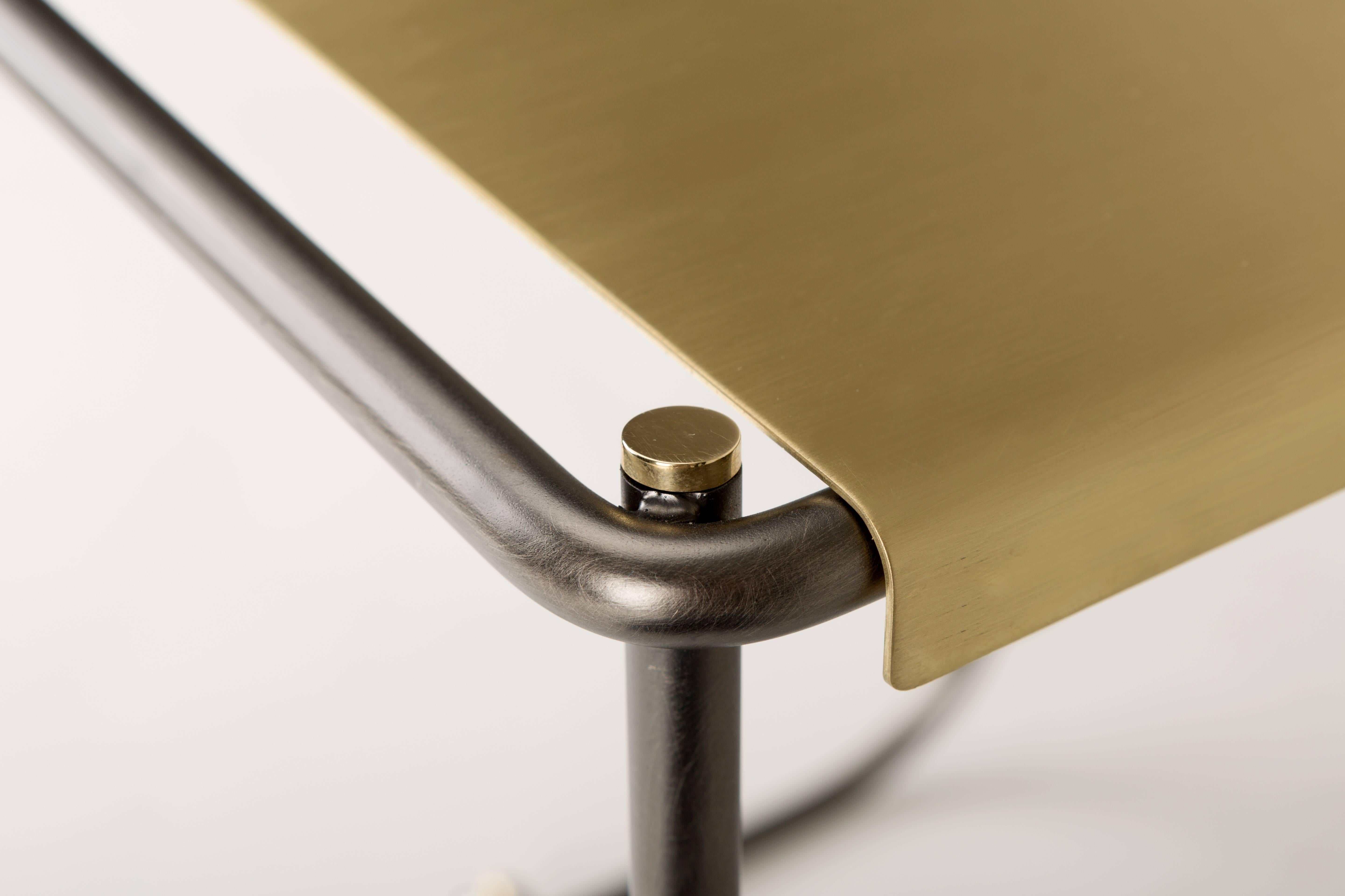A bent metal tube surrounds the seat made from a galvanised plate with a brushed finish. Brass screws at the end of the tubes enrich its simple shape.

Materials: bent metal tube structure and natural brass seat
Dimensions: cm 38 x 36.5 x 46.5.