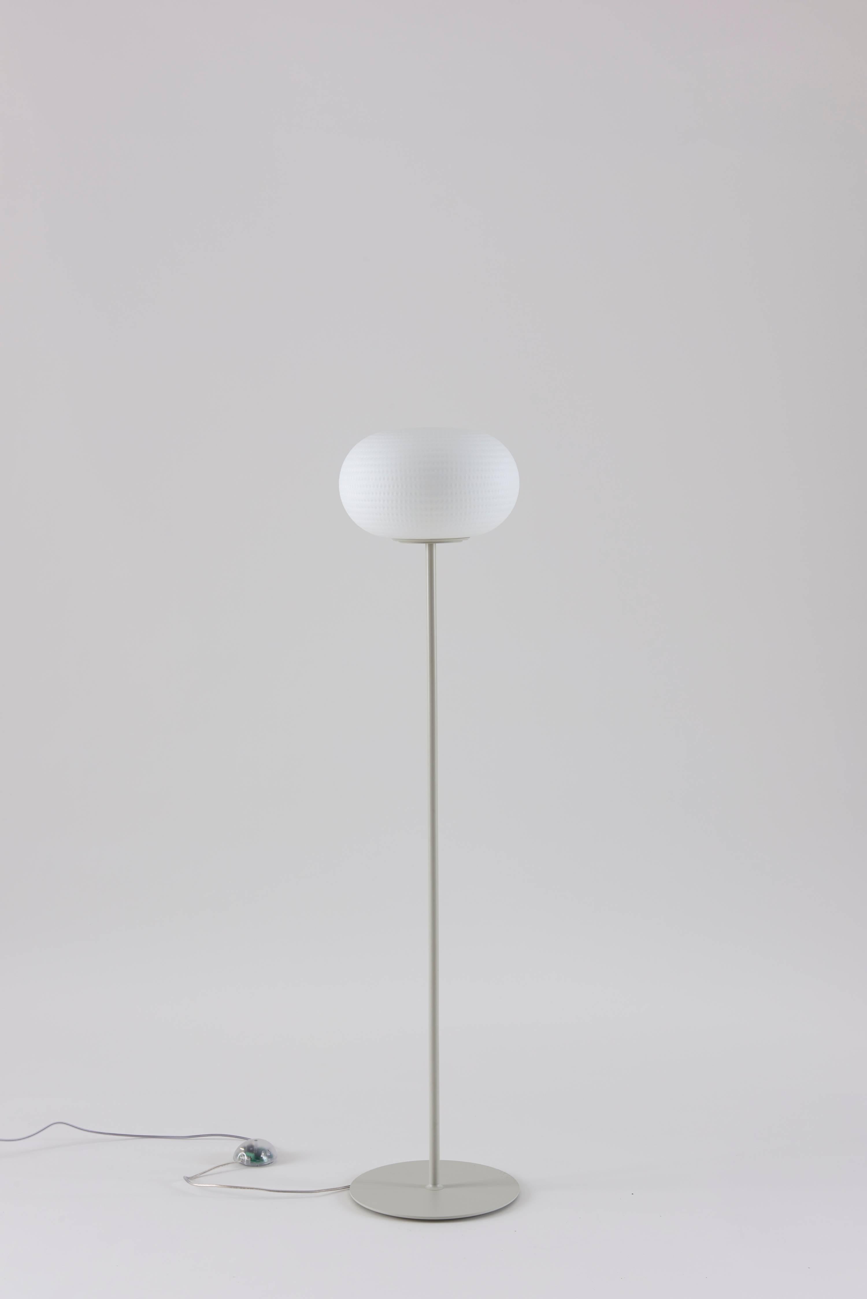 Designed by Matti Klenell in 2015 and manufactured by Fontana Arte, the Bianca floor lamp is a family of lamps with diffuser in blown glass, comprising pendant, floor, wall/ceiling and table versions, the latter with or without base. Its beautifully