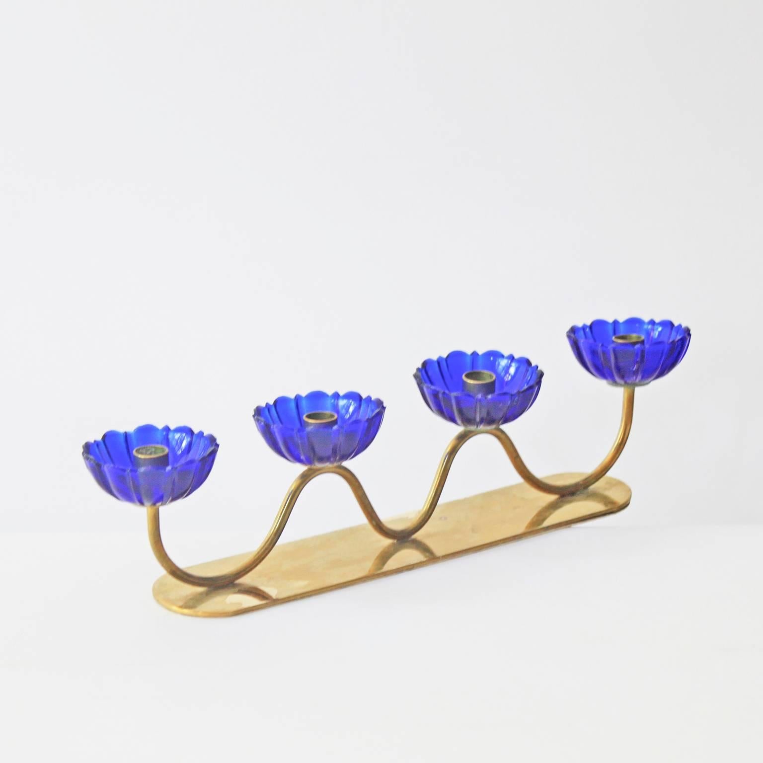 A series of four blue flower candle holders by Gunnar Ander for Ystad-Metall. This piece comprises blue flowers on an undulating base of patinated gold-plated brass.