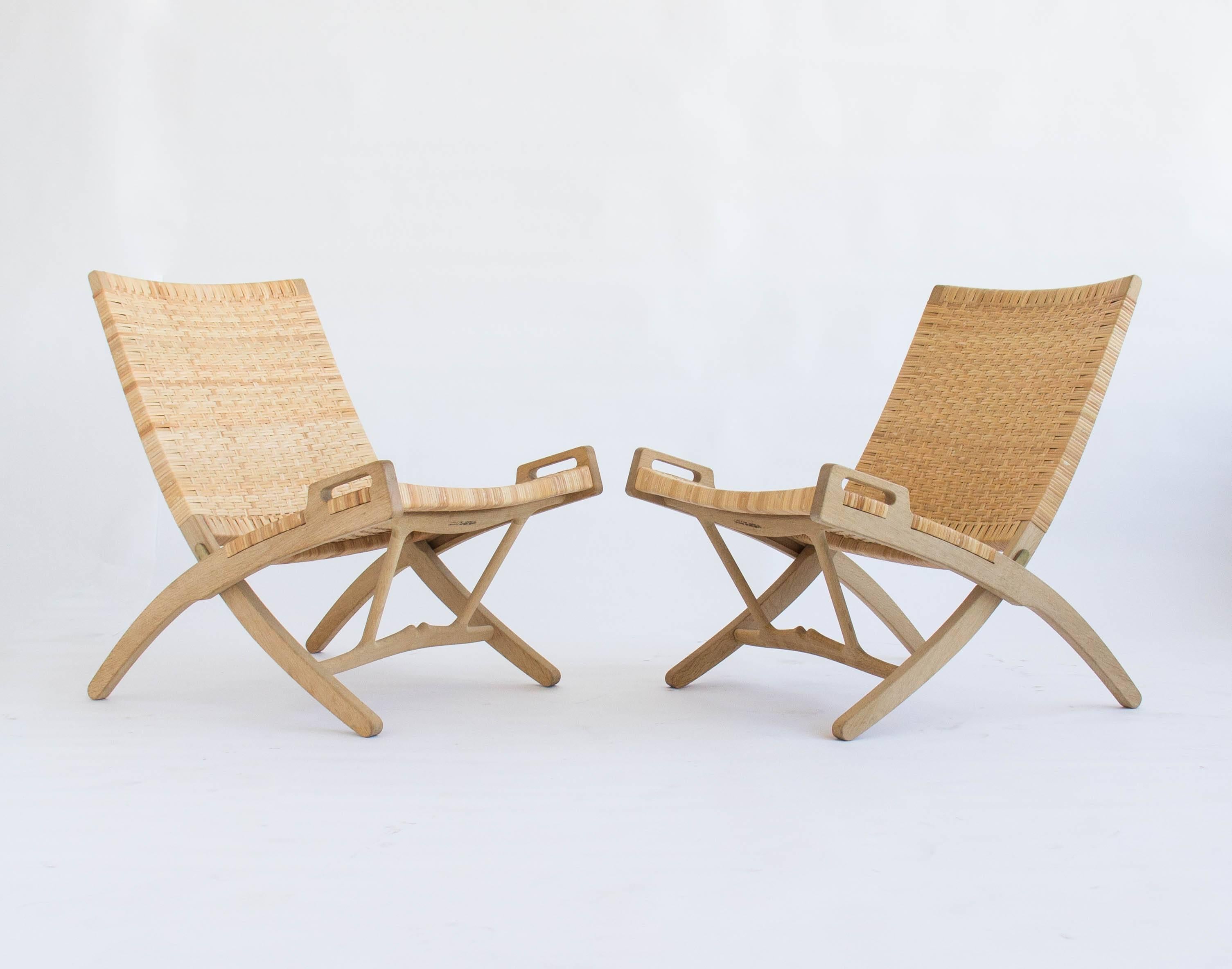 Pair of folding lounge chairs made by PP Møbler in 2007. The pair was designed by Hans Wegner in 1949. For many years this design was produced by Johannes Hansen.

Each chair includes oak wall hook so the chairs can be hung while not in