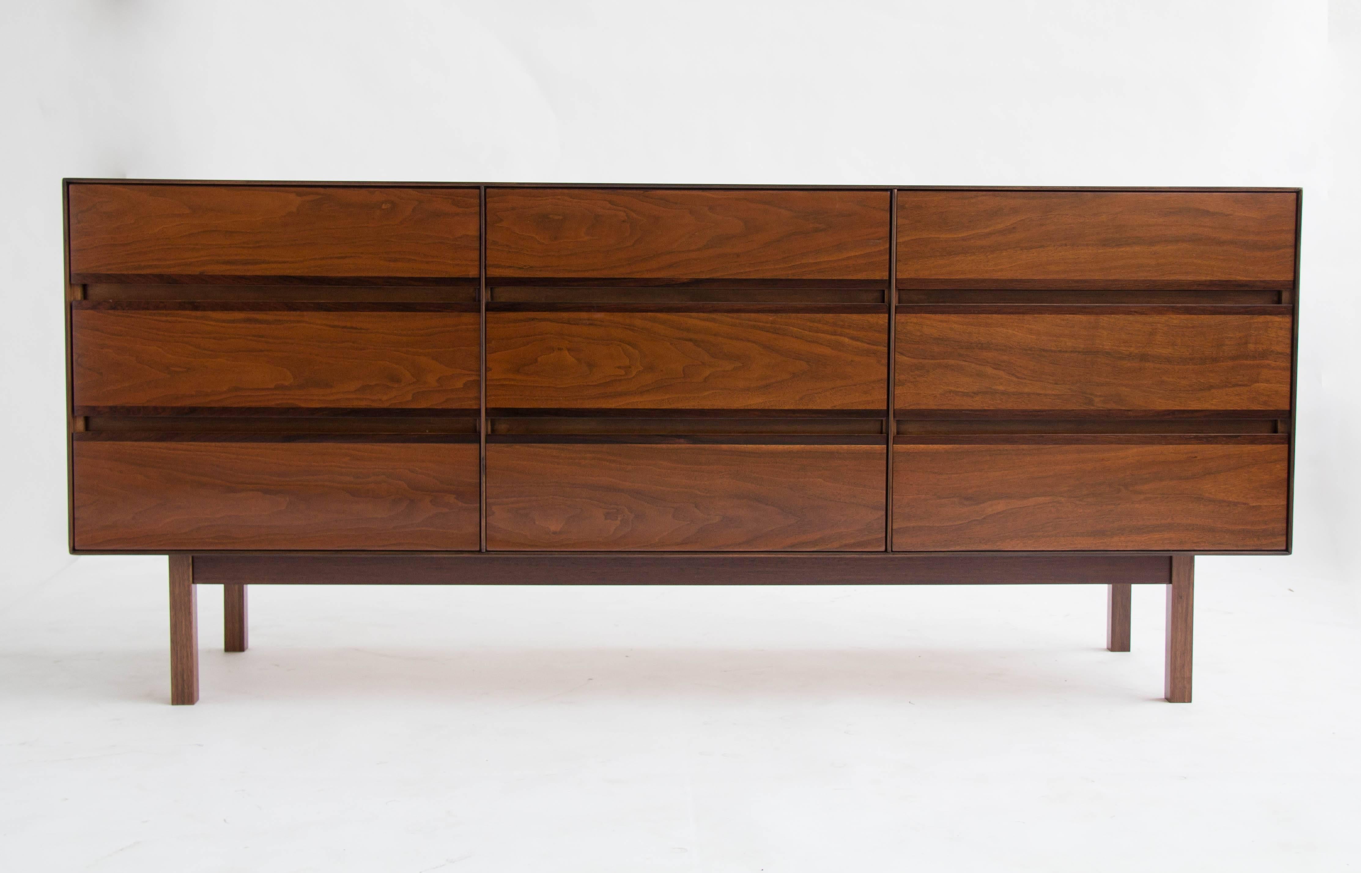 Deceptively minimal design by H. Paul Browning for Stanley’s “Royal American” collection has nine drawers in a walnut frame, resting on four recessed legs. The front panel of each drawer has a slim band of rosewood veneer. Drawer edges are sculpted