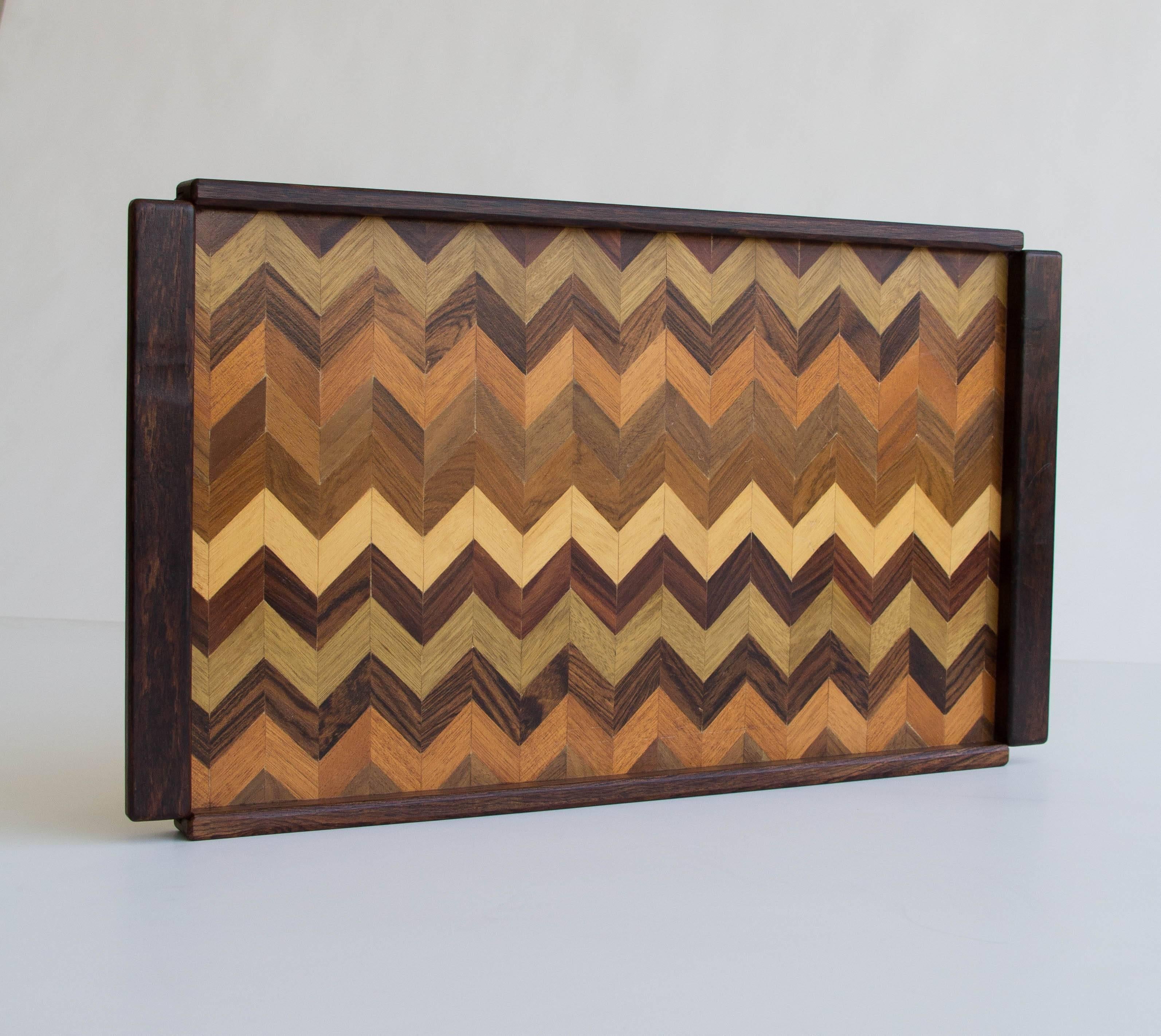 Rosewood serving tray by Don Shoemaker for his company Señal in the 1960s. The surface of the tray is has a chevron-patterned parquet detail in exotic woods. Label on bottom reads, “Designed by Don S. Shoemaker, Produced by Señal S.A., Sta. Ma. de