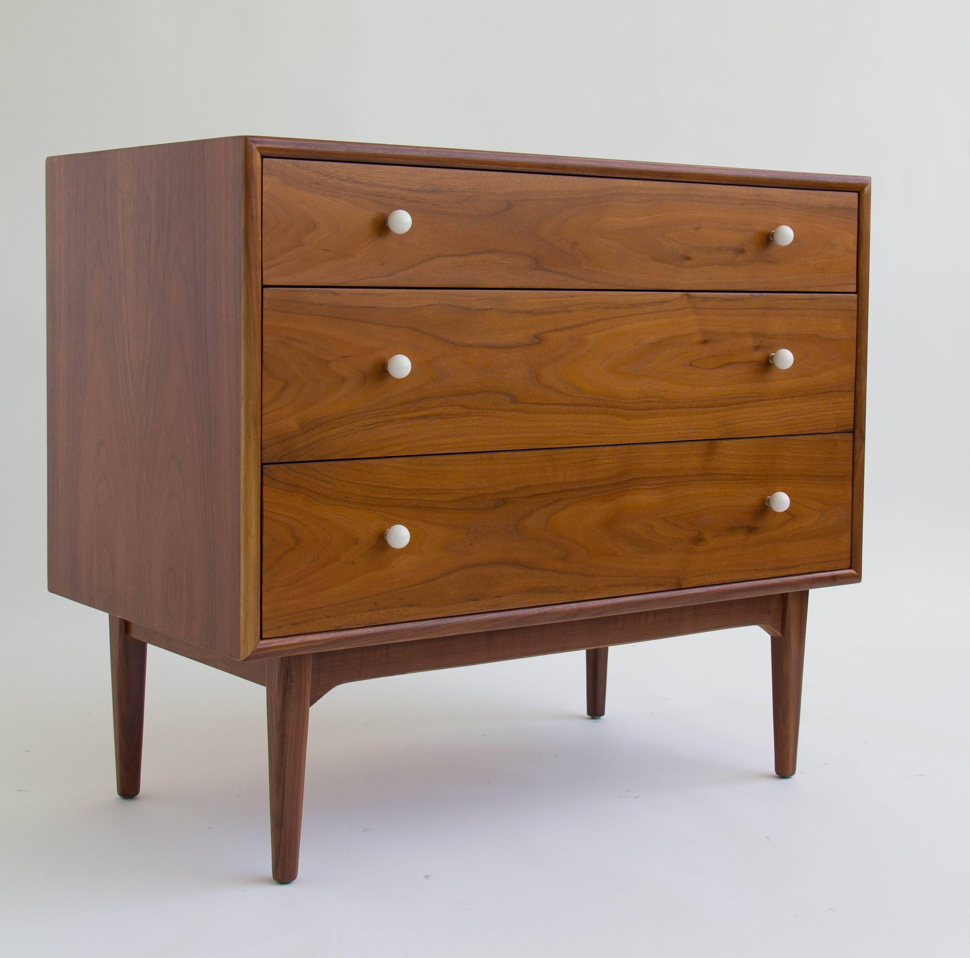 Walnut dresser from Drexel’s popular Declaration collection by Kipp Stewart and Stewart McDougall. This example has a walnut case holding three drawers with original white ceramic knobs on brass spacers. Upper drawer has the Drexel manufacturer’s