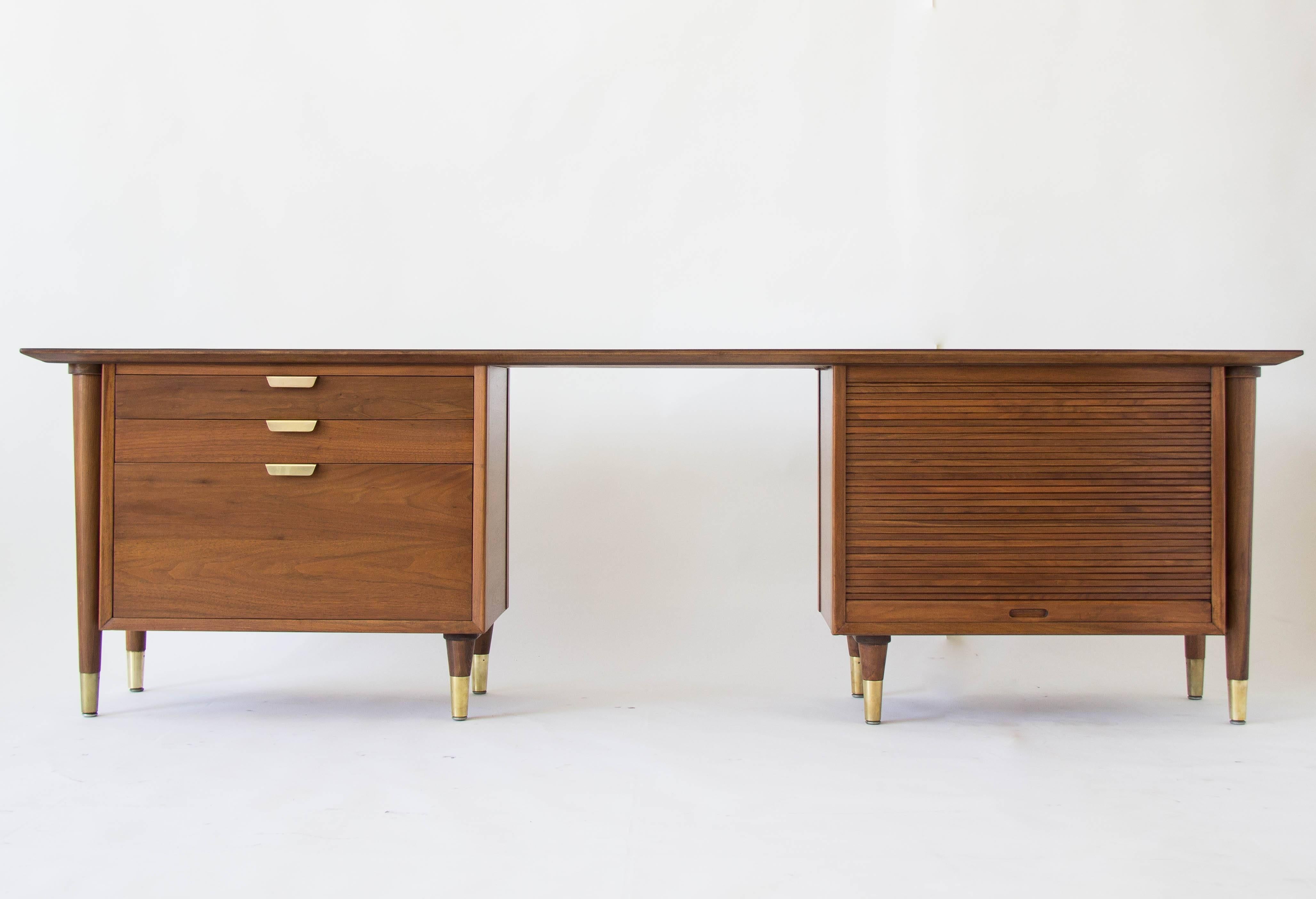 Distinctively long and narrow design by William H. Sullivan for Standard Furniture Co. This American made walnut credenza has a slender tabletop supported by two storage stacks. The right side has a tambour door that opens onto interior storage