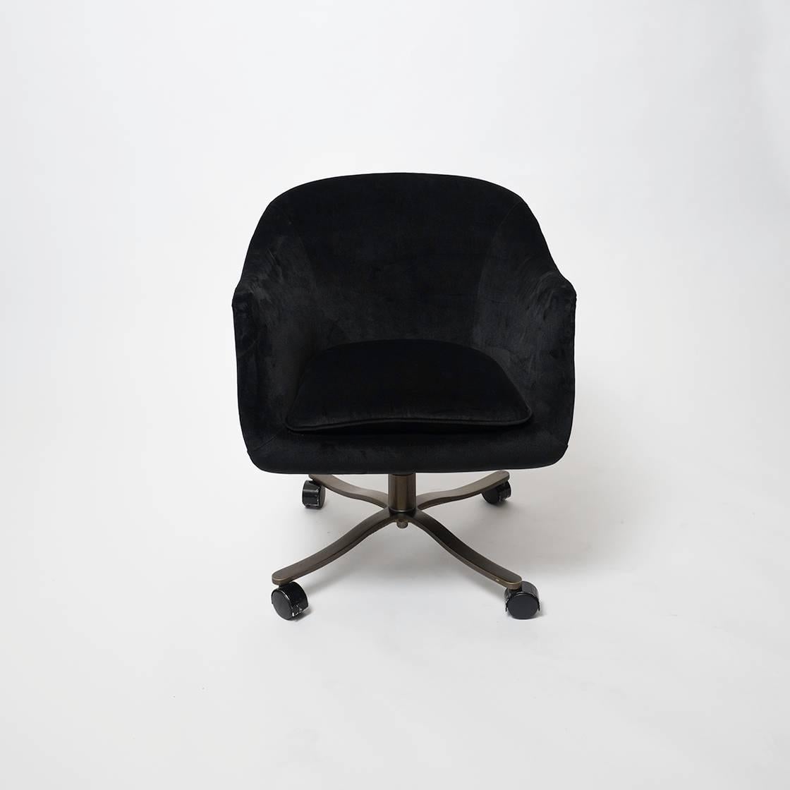 The CH6 bucket chair designed by Nicos Zographos in 1964. This is the swiveling version with a four-star bronze base and original Shepherd casters. The body of the chair is upholstered in the original black velveteen fabric, which is in pristine