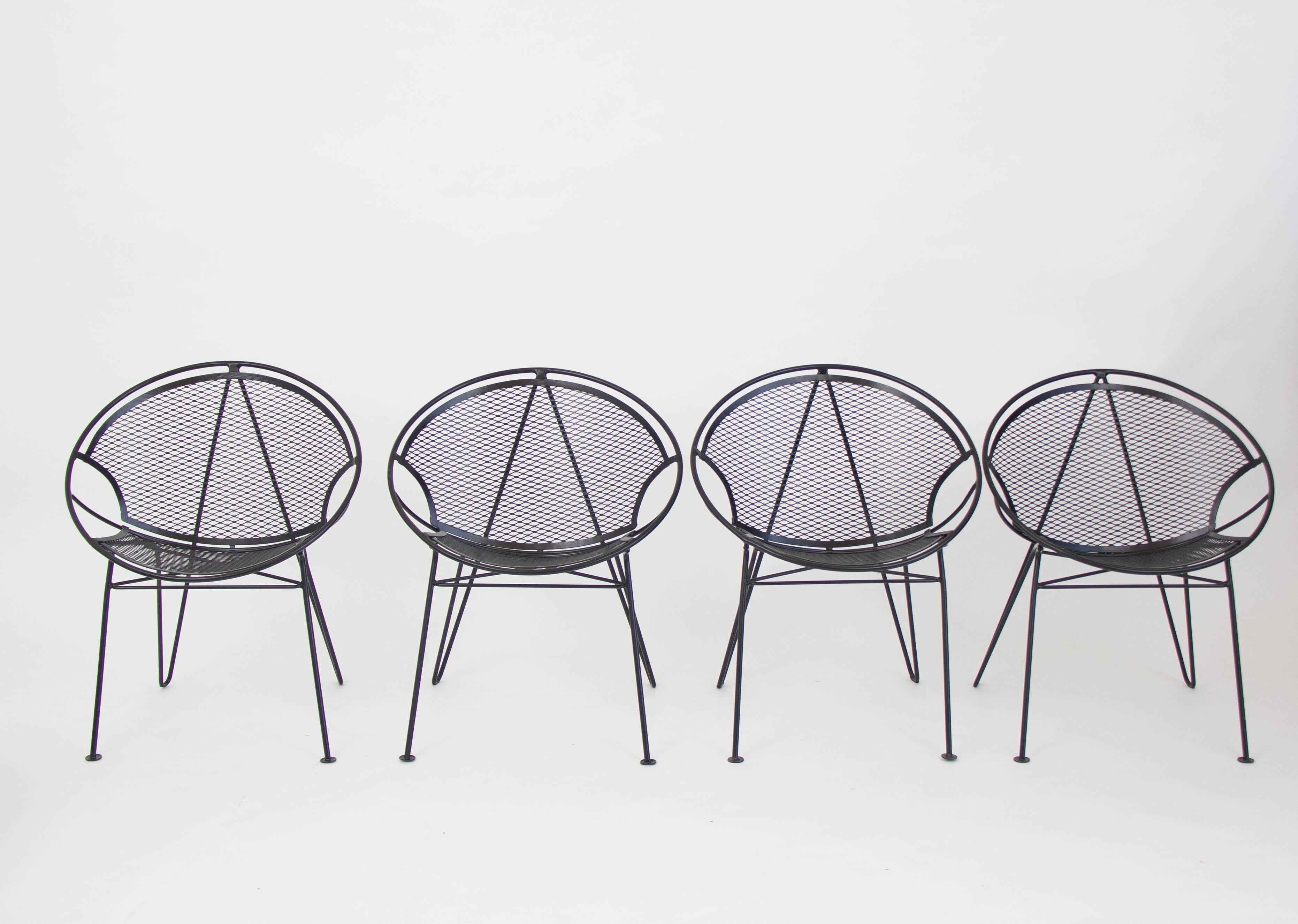 A four-person wrought iron patio dining set from Maurizio Tempestini's “Radar” collection for John Salterini. The chairs have a bisected hoop construction with a delicate grid of wrought iron forming the body, and sit on four angled legs with flat