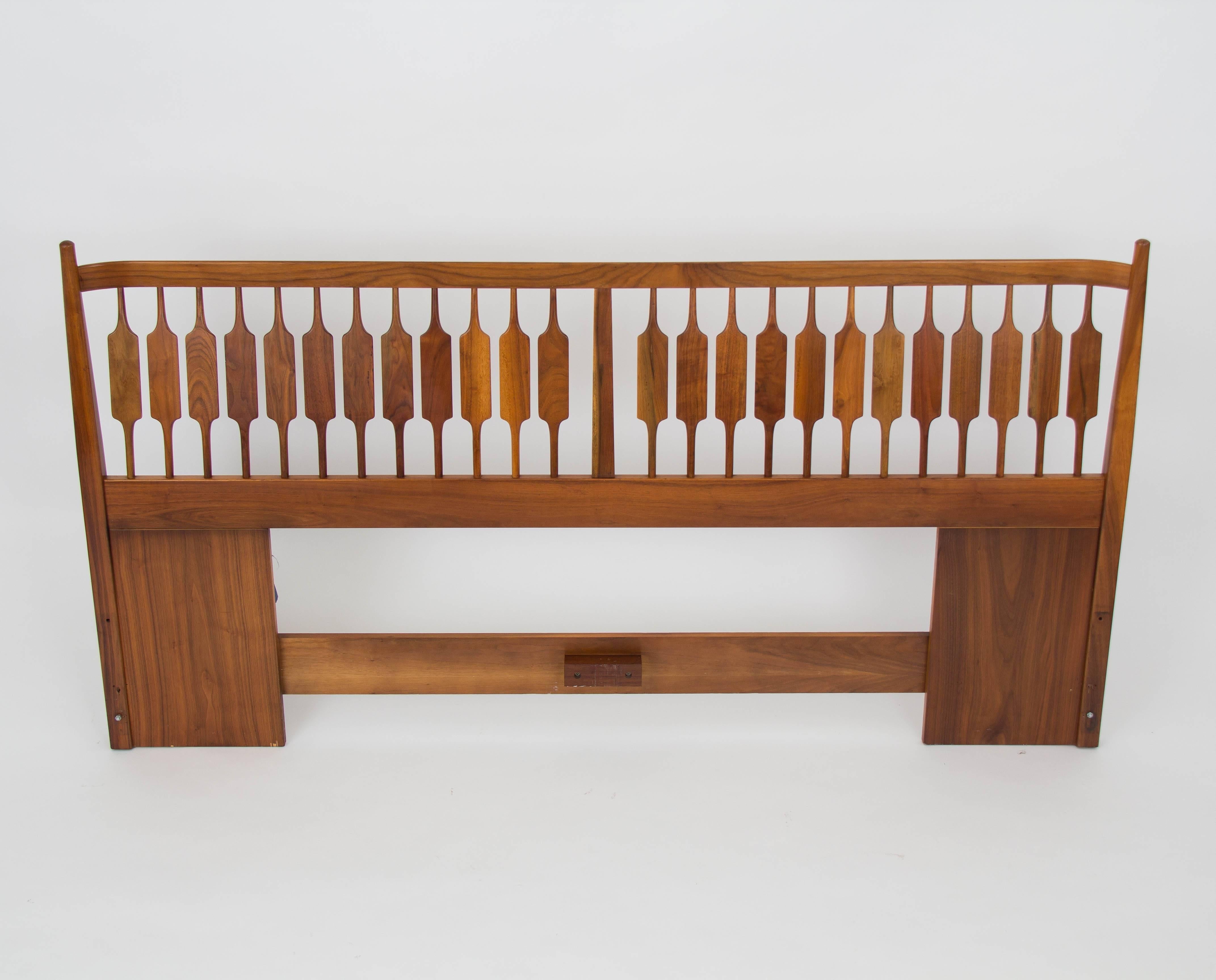 A king-sized headboard from Drexel’s popular Declaration collection designed by Kipp Stewart and Stewart MacDougall. This example is the “Catkin bed,” named for the reed-inspired sculpting on the dowels. The piece, made of walnut, has a tapered post