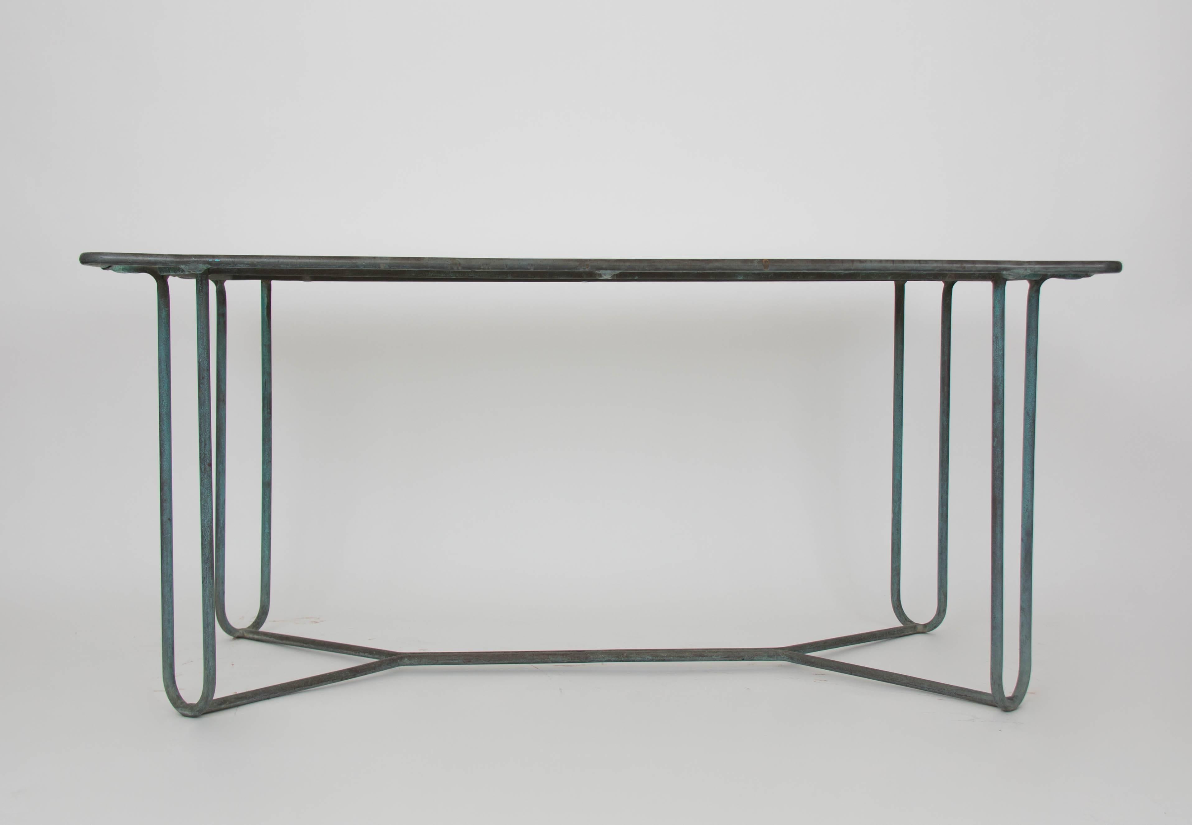 A patio dining table in patinated bronze designed by Walter Lamb and produced by Brown Jordan. The table has a rectangular shape with rounded corners, supported by four hairpin legs in matching bronze. The legs are joined by diagonal stretchers and