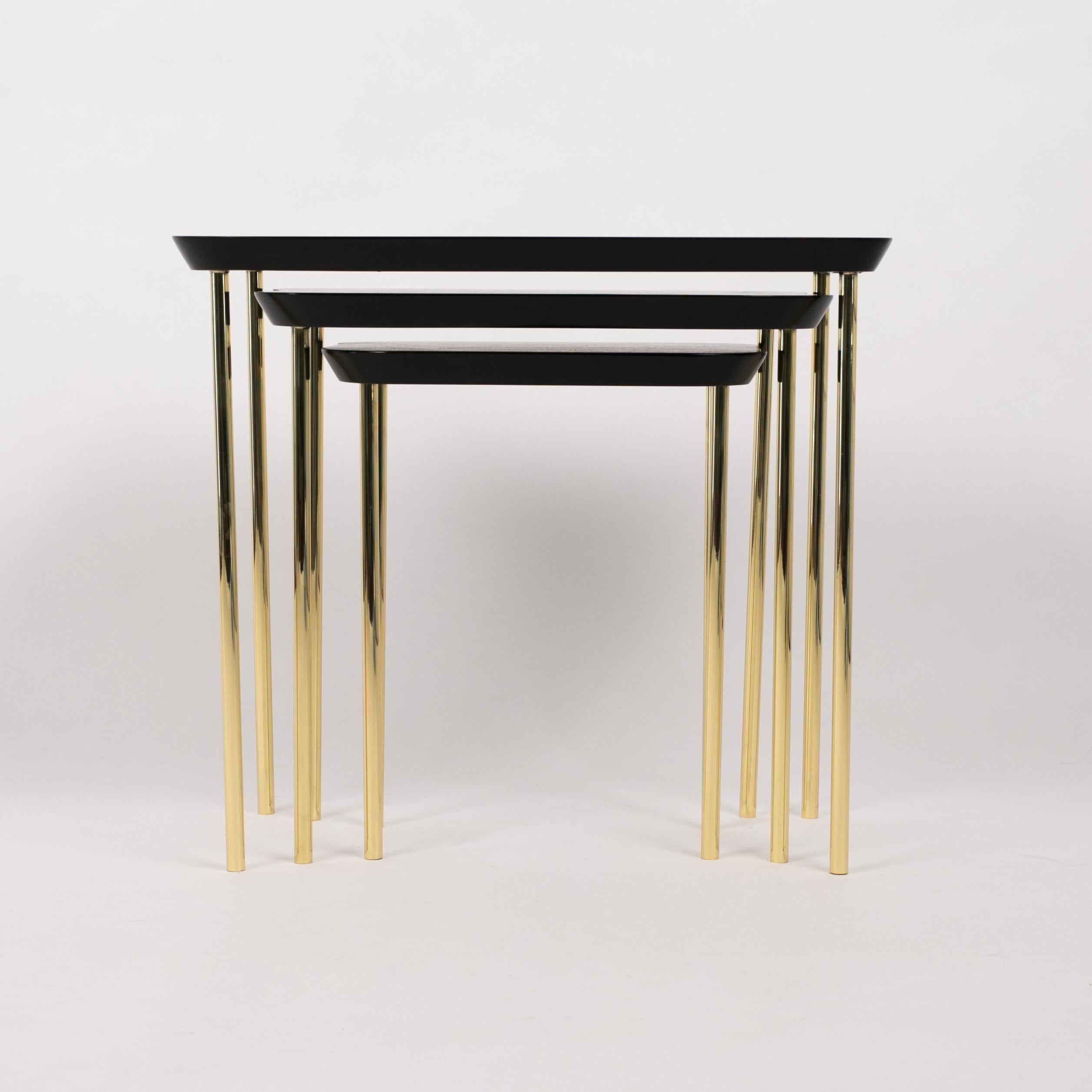 A set of three modernist nesting tables from Boston's Charak modern. Charak pieces are distinguished by their transitional qualities, and these modern pieces are also in conversation with Hollywood Regency and Art Deco silhouettes. The largest table