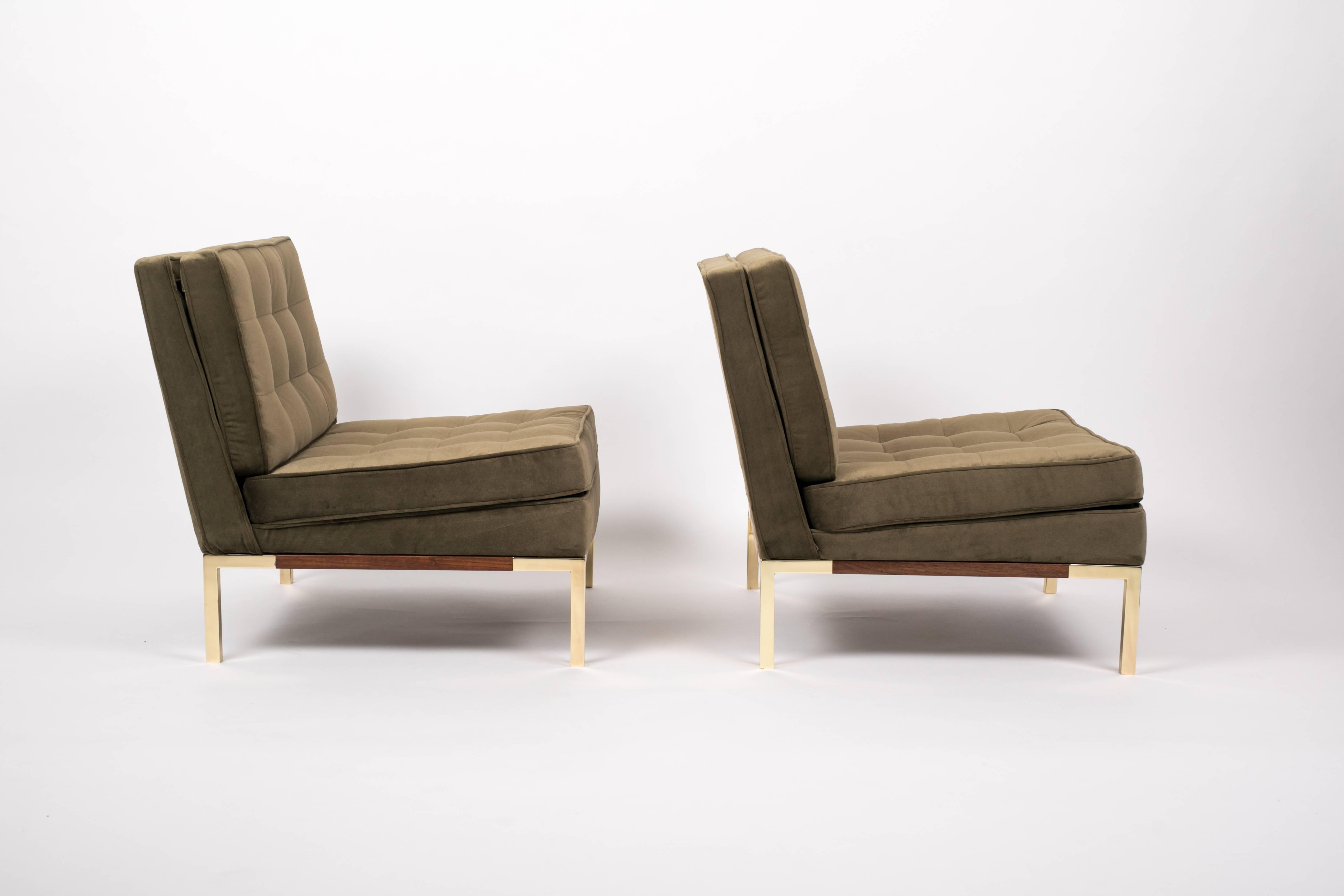 A pair of fully restored slipper or lounge chairs by Lee Woodard for Woodard Furniture. The olive green velvet upholstery is quilted according to the original design and welted corners emphasize the structured design. The chairs sit on a walnut base