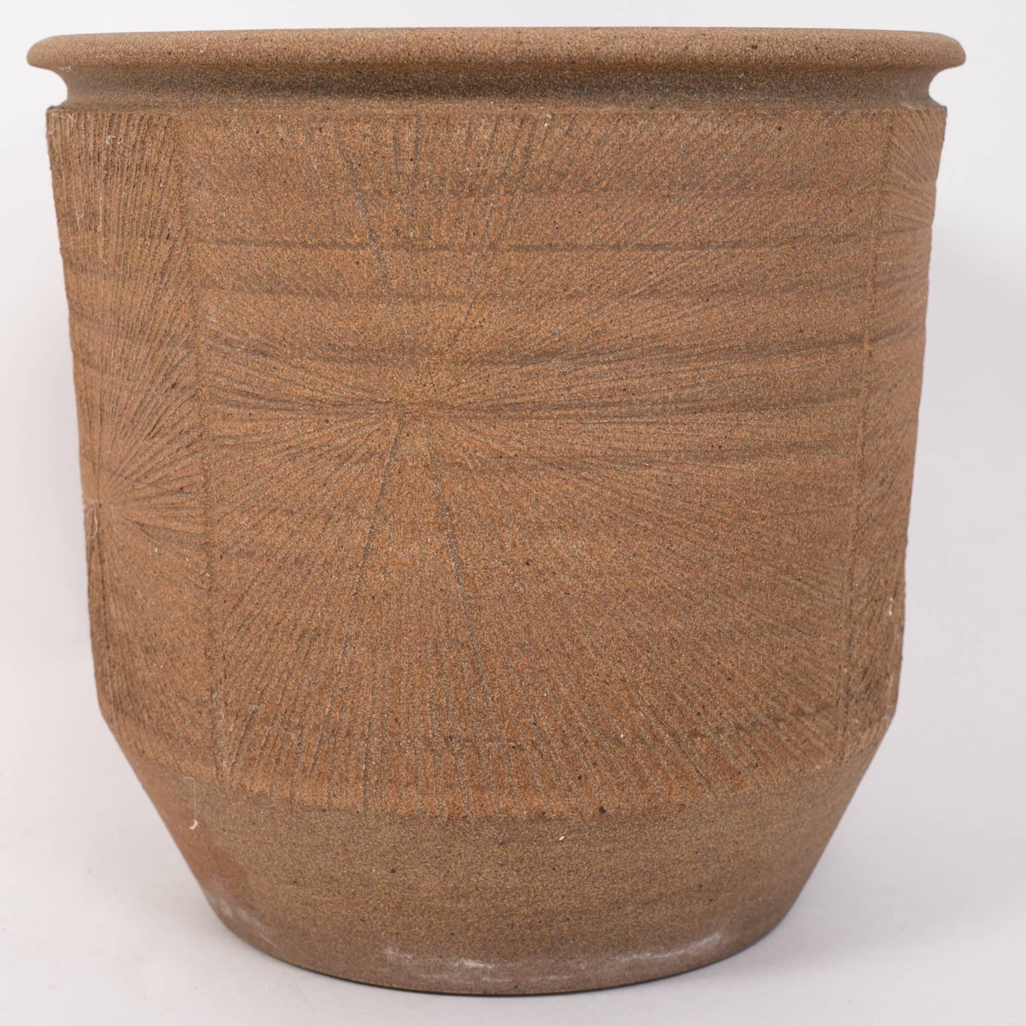 A 1970s handmade Studio Pottery planter by California ceramics artist Robert Maxwell. This example has a notched lip and cylindrical shape. It is hand incised with a Maxwell signature “sunburst” design. The interior of the planter is glazed and a