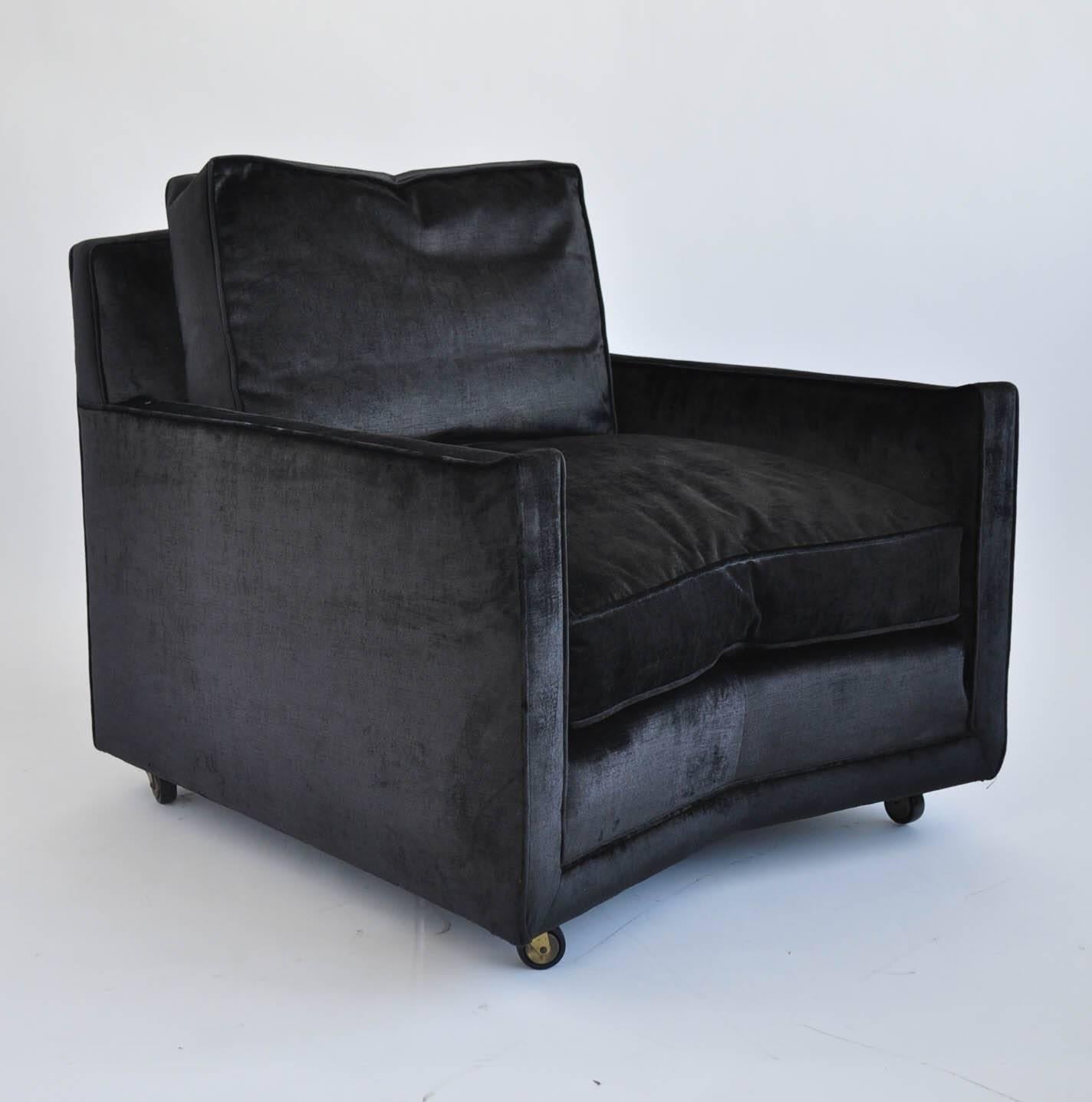 Lounge chair and ottoman by Baker Furniture company features down filling on both the chair and ottoman. The ottoman and chair sit on brass castors. 

Chair dimensions: 38