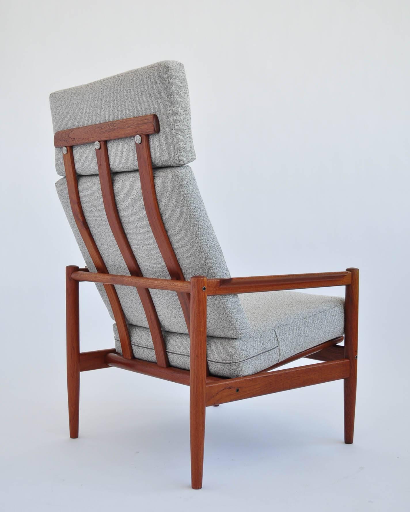 This is teak lounge chair by Borge Jensen designed in the 1950s. The chair is made of teakwood and has been reupholstered in contrasting gray fabric.