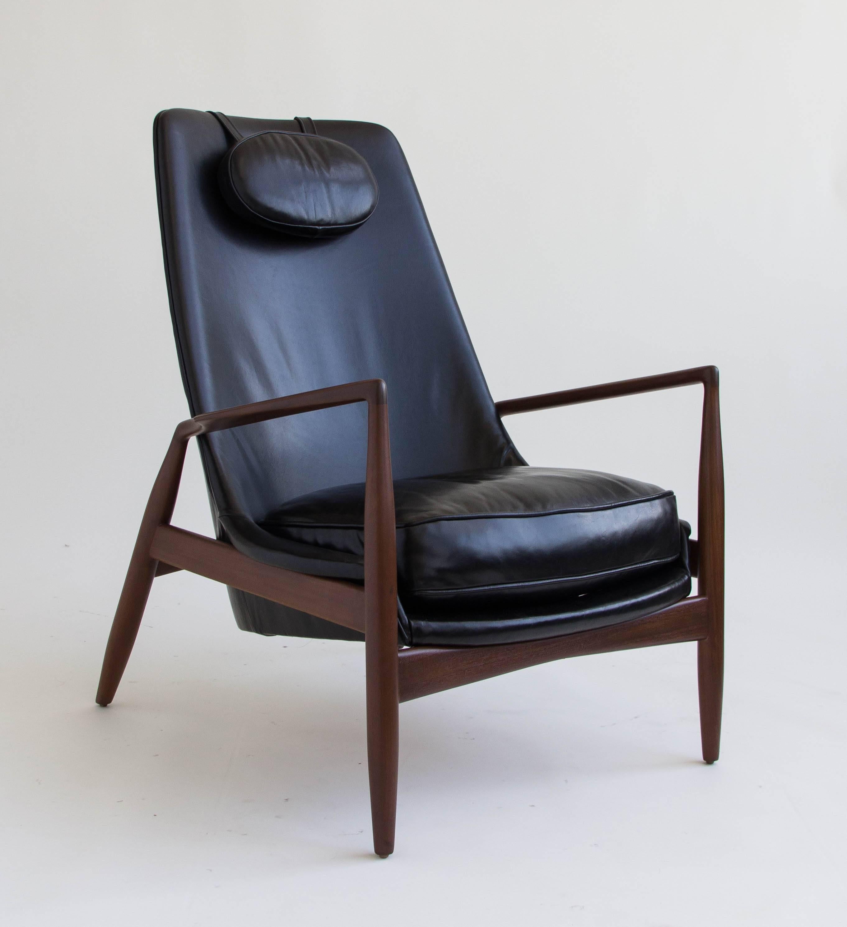 High-backed seal chair by Ib Kofod-Larsen, manufactured by OPE of Sweden. This lounge chair has been re-upholstered in sumptuous black leather. The chair sits at a reclining angle on a slender teak frame with sculpted armrests. Stamped “Made in