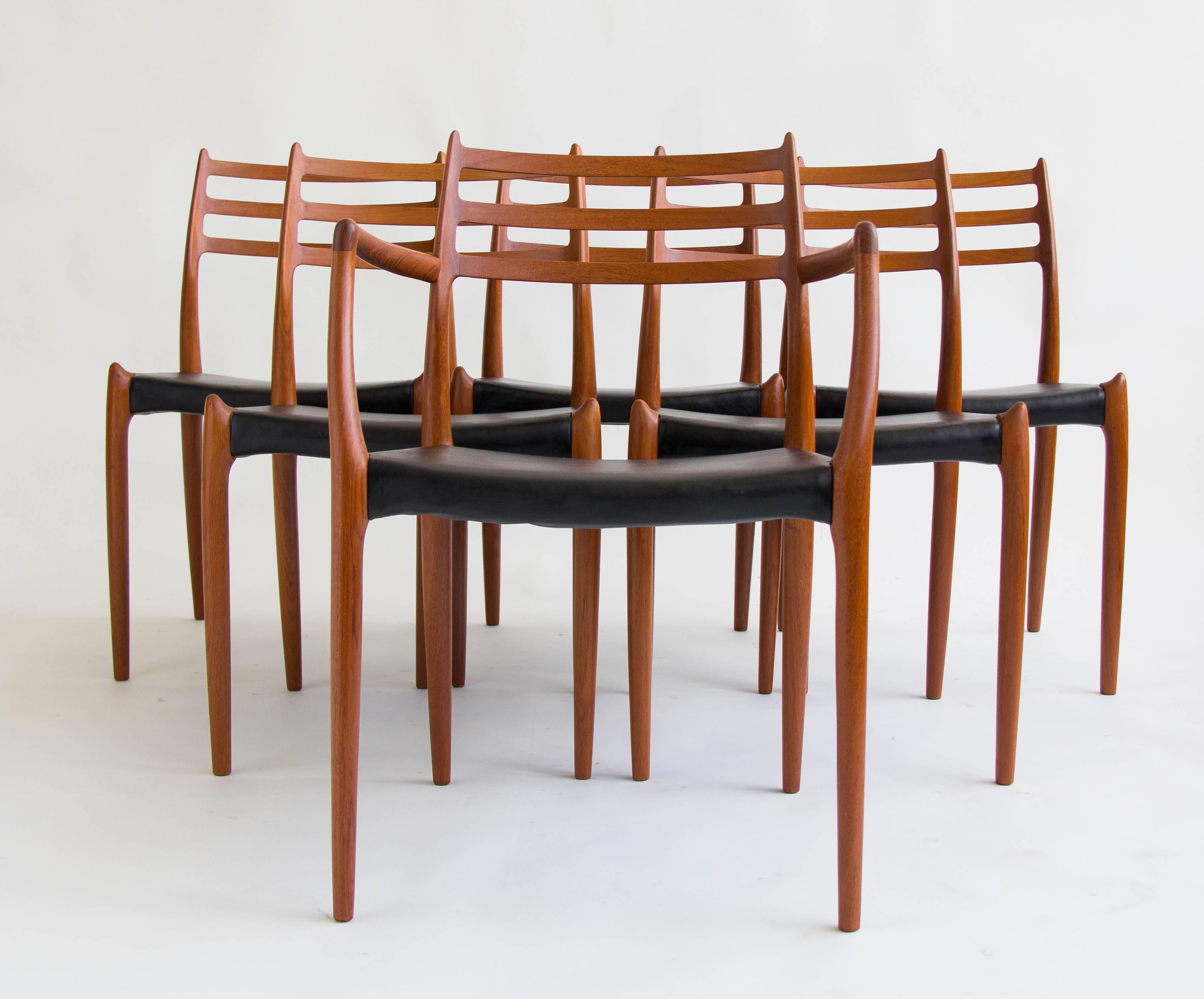 Set of six teak dining chairs designed by Niels Møller in 1962 and manufactured by JL Møllers Møbelfabrik of Denmark, with original black vinyl seats. The chairs have a curved backrest with three horizontal supports. The set is comprised of one