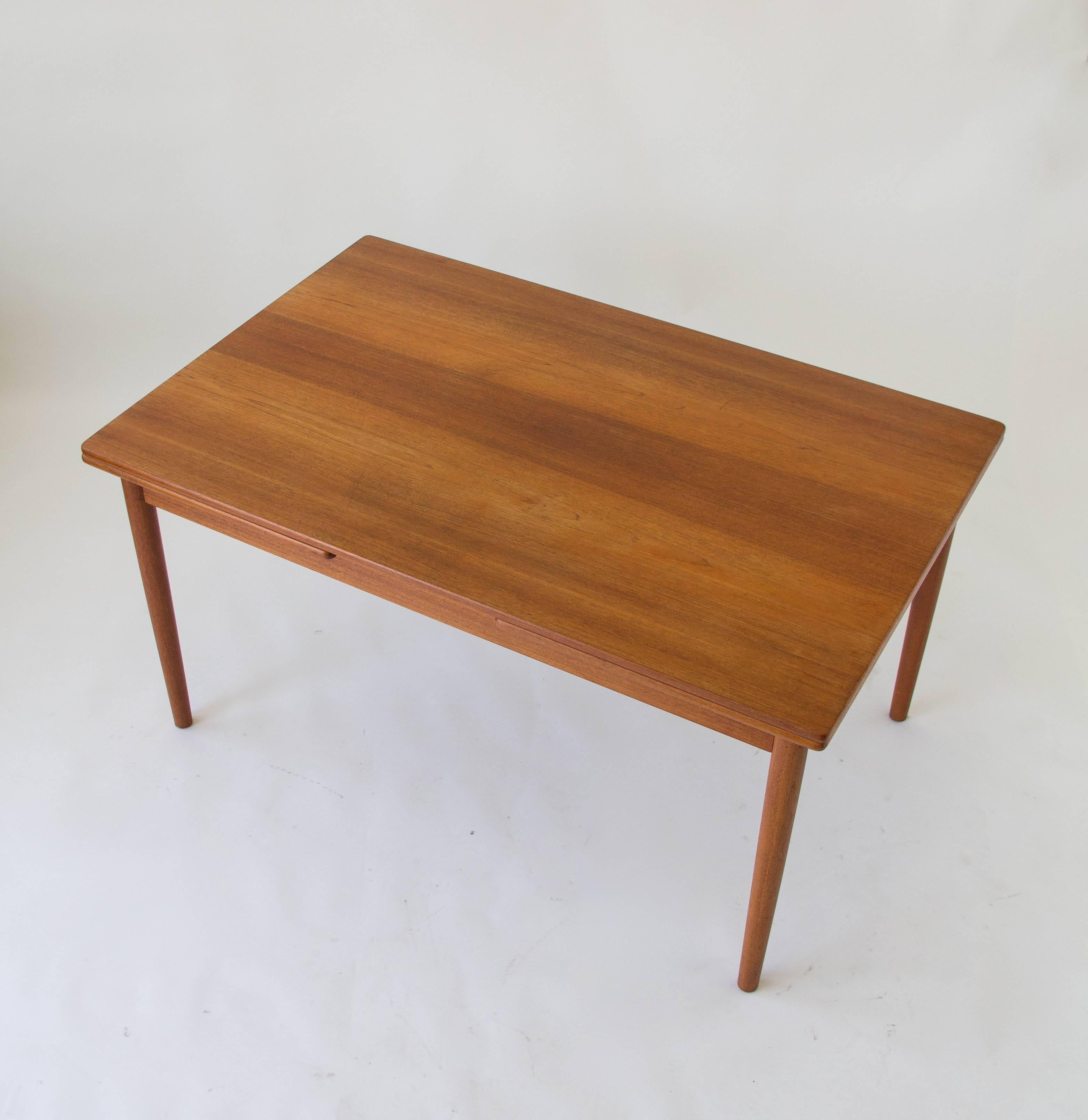 Rare teak dining table by Hans J. Wegner for Andreas Tuck. Designed in the 1950s, the table has two extension leaves that draw out from beneath the tabletop, and raise to sit flush at their full length. The underside is stamped, “Fabrikat: Andr.