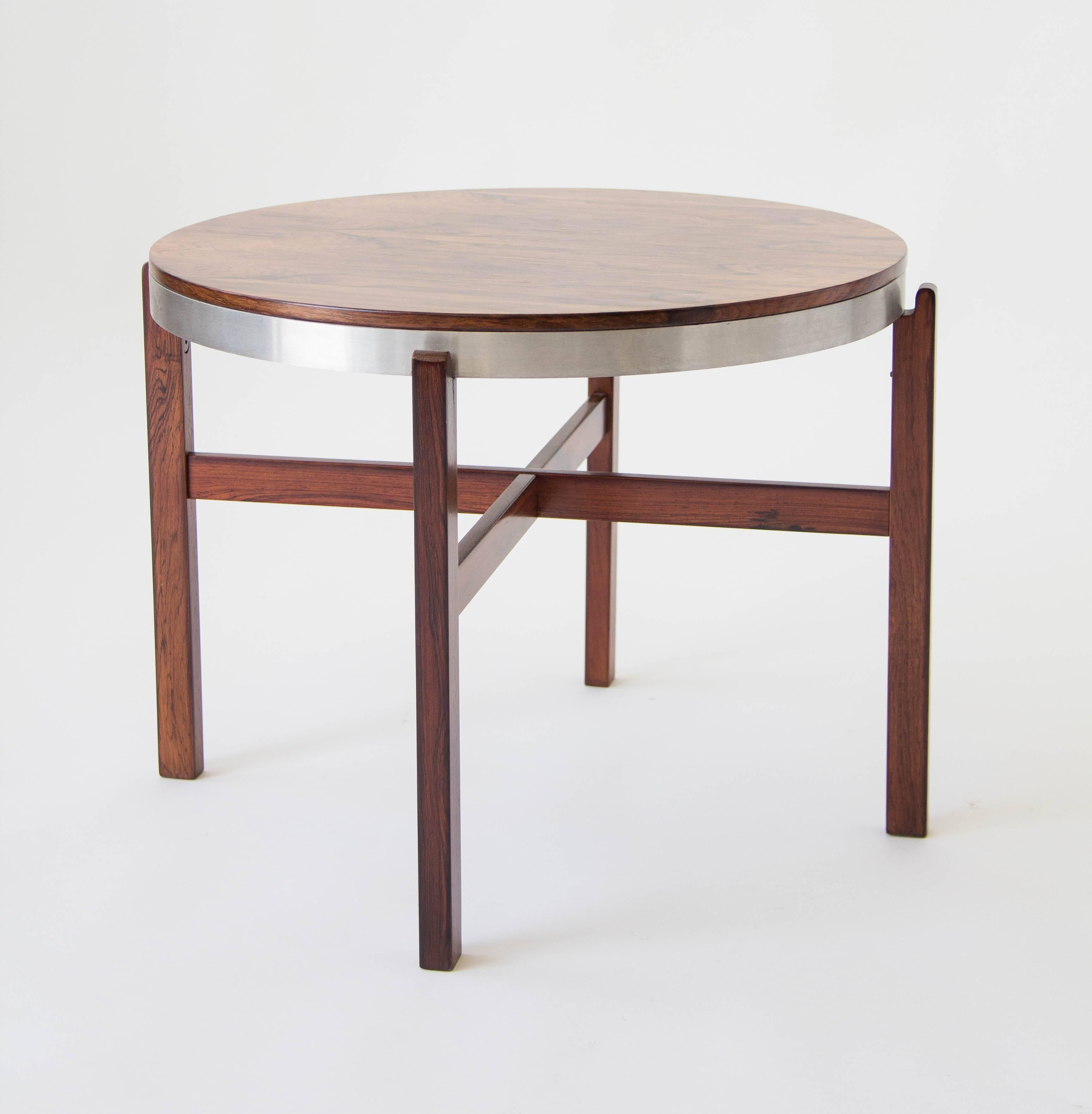 This Danish modern tray table has a four-legged frame supporting a brushed aluminum ring. A removable rosewood tabletop with beautiful wood grain fits into the metal frame, or can be used separately as a tray. 

Condition: The table has been