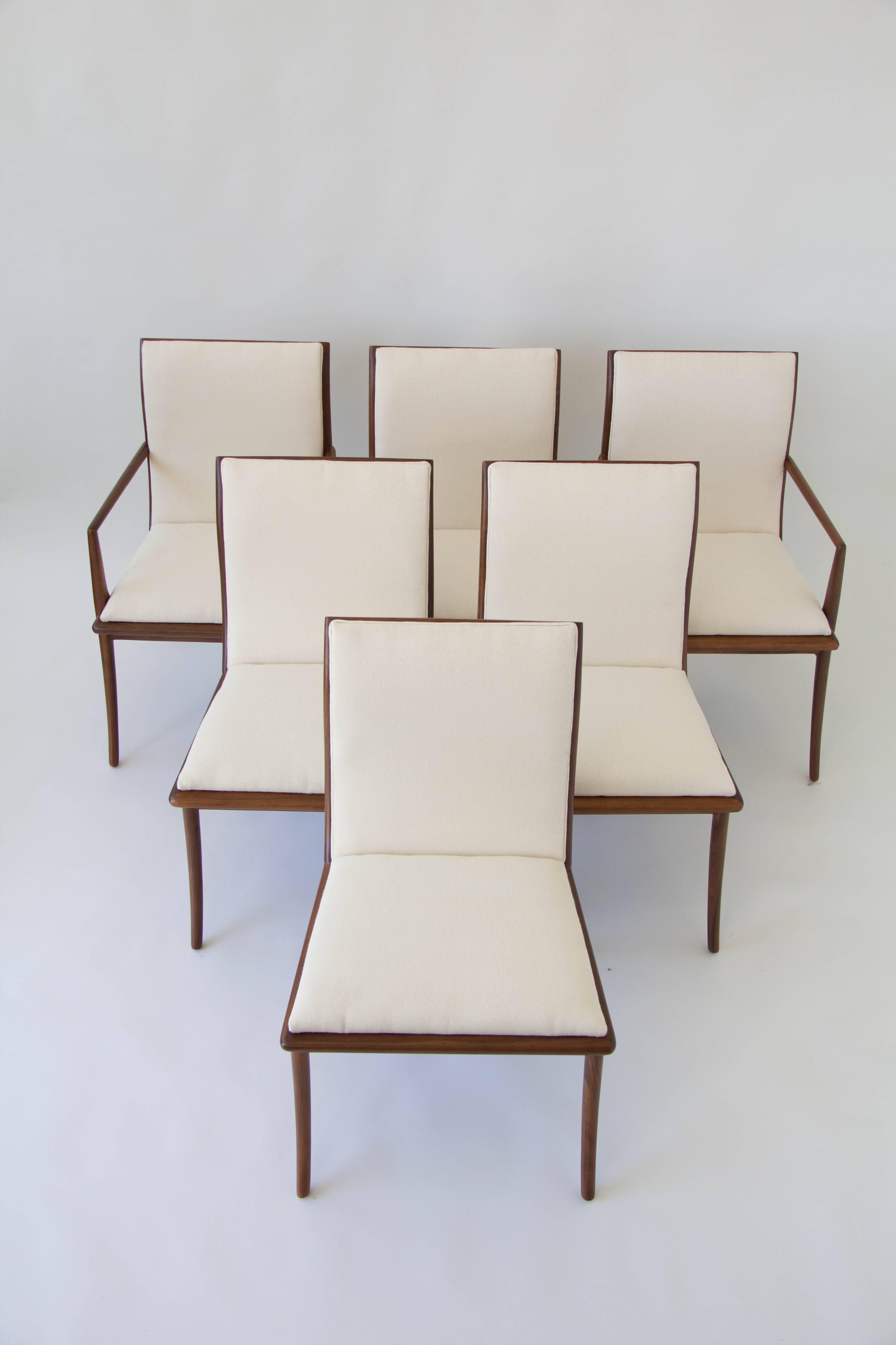 American-made dining set by T.H. Robsjohn-Gibbings for Widdicomb consists of six chairs, two armchairs and four side chairs. The chairs have a sabre-leg design with sculptural backs. New upholstered in a slightly textured off-white cloth that shows