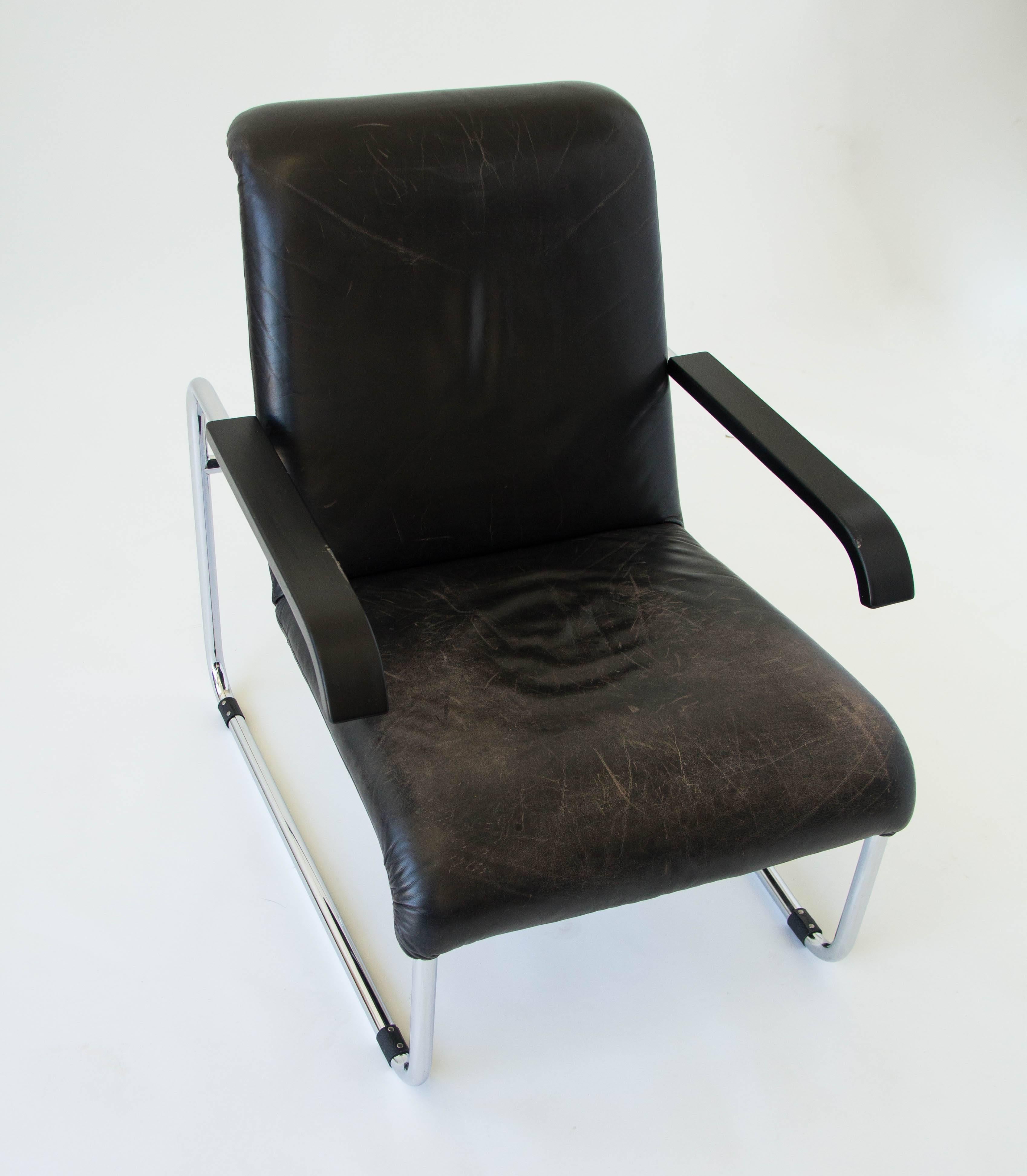 An original Marcel Breuer B35 lounge chair in black leather with painted wooden armrests. Designed in 1928 and produced by German manufacturer Thonet, this example has a foam padding. Other variants have included cane or sling upholstery. The chair