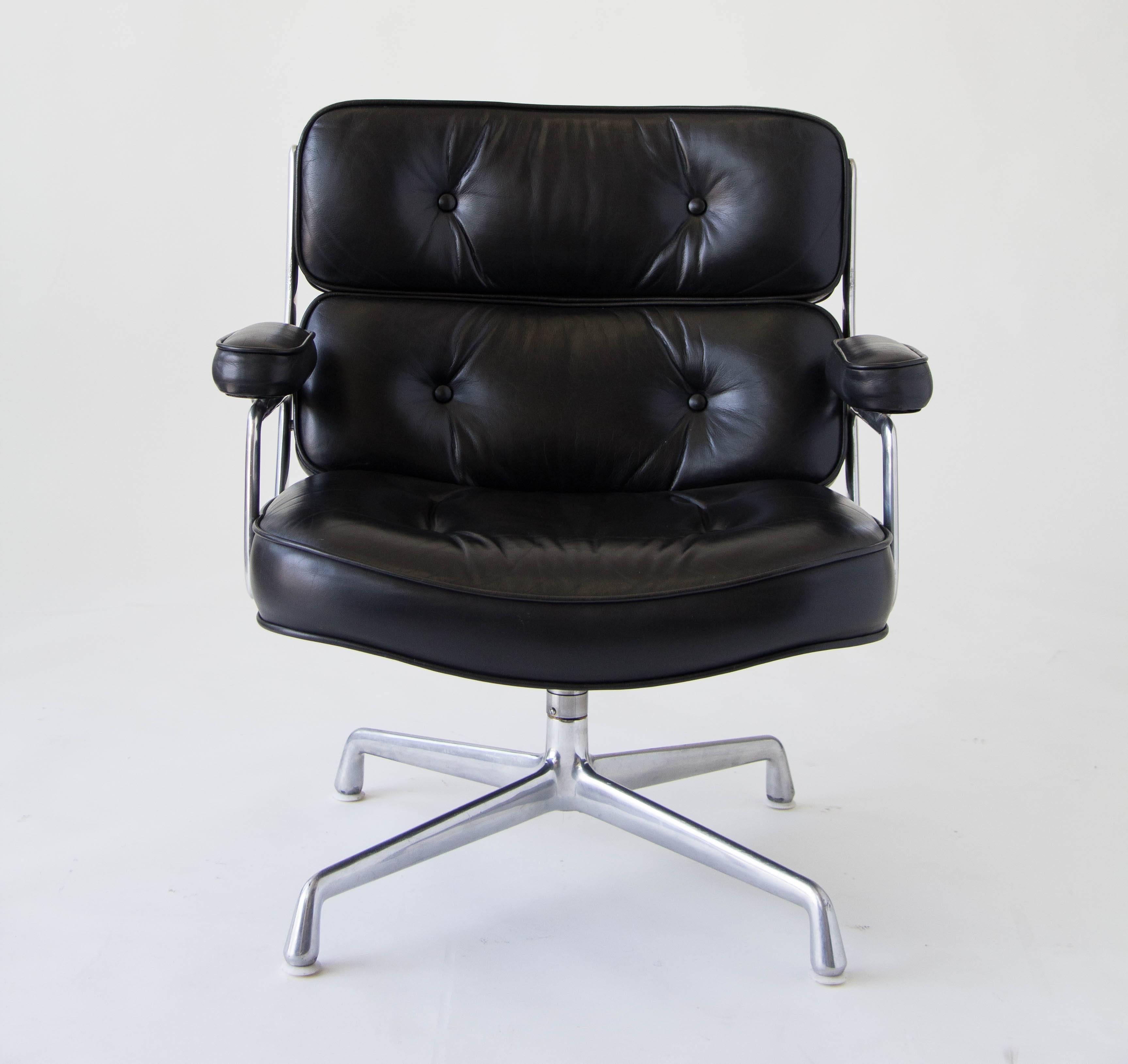 Designed in 1960 by Charles Eames for the Time Life Building in Manhattan, this chair features a polished aluminum frame and sumptuous tufted cushions in the original black leather. The chair sits on four plastic glides. This is the slightly wider