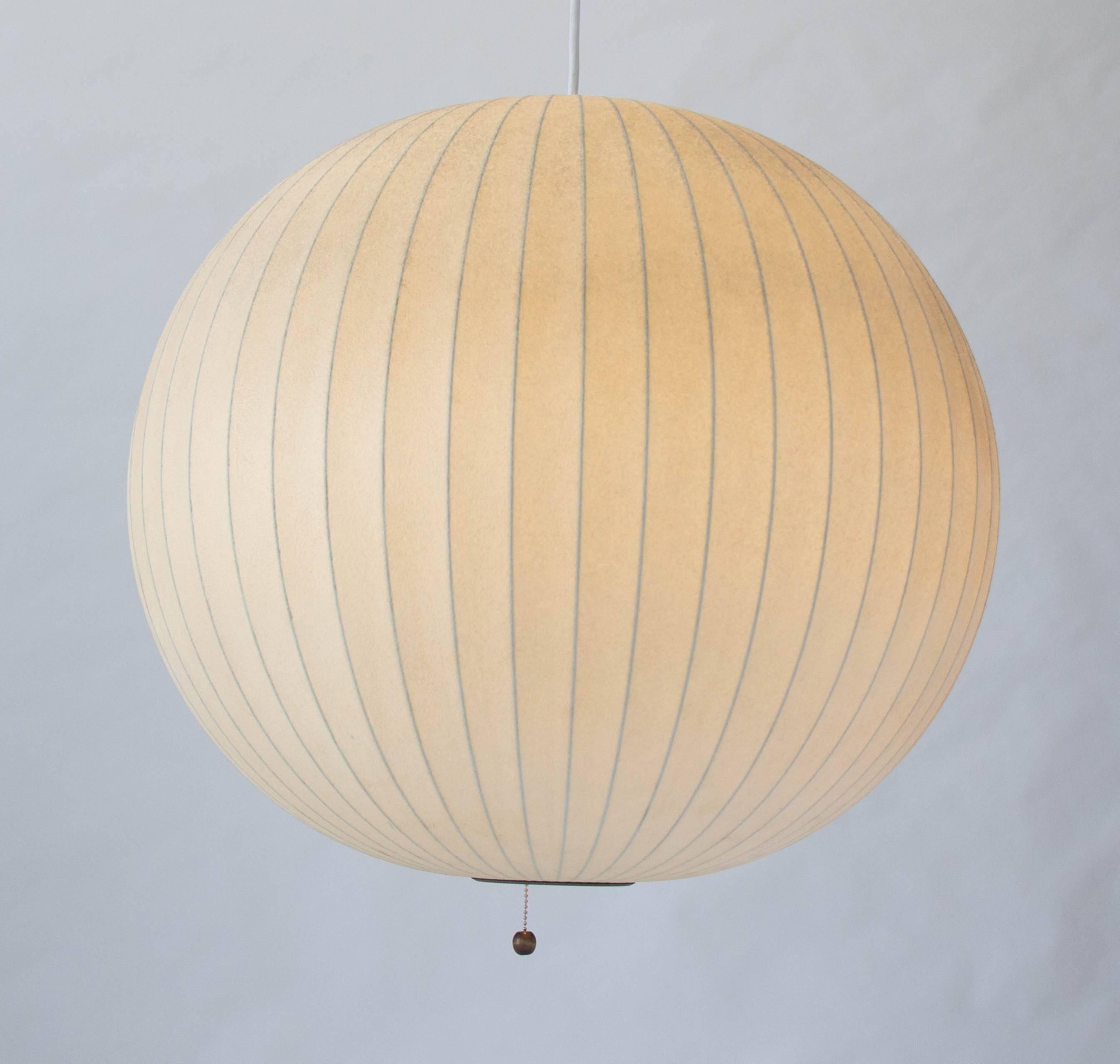 An original H-725 bubble lamp (now referred to as “Ball Pendant” variant) designed by George Nelson for Howard Miller in 1947. The lightweight steel frame is covered in the original plastic webbing with a pull chain to turn the lamp on and off. This