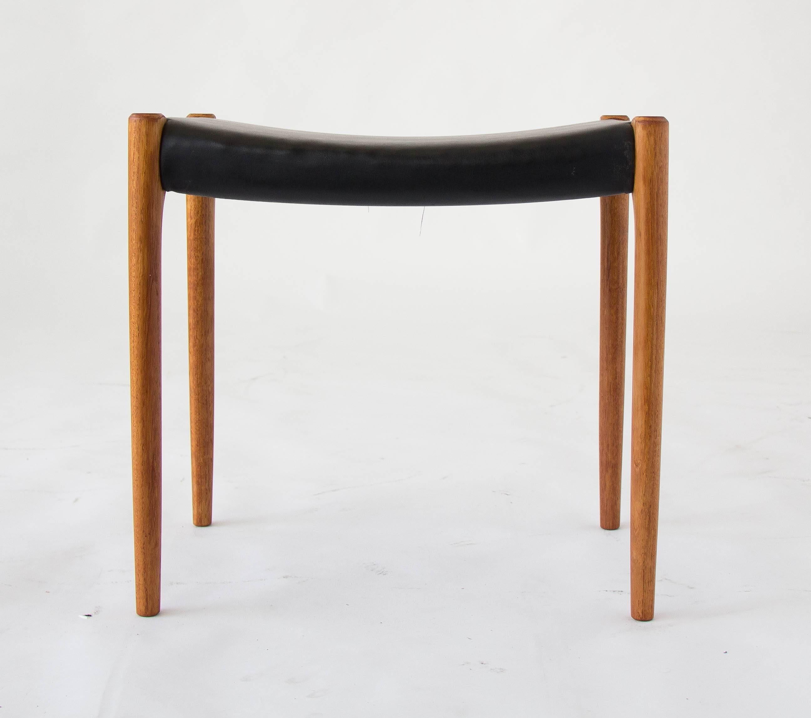 Simple ottoman with slightly tapered legs, designed by Niels Møller for JL Møllers Møbelfabrik of Denmark. The vinyl upholstery is original and the legs and frame are solid teak. 

Condition: Excellent vintage condition; professionally cleaned and